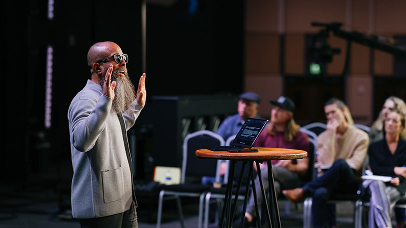 Apostle teaching from stage at KINEO