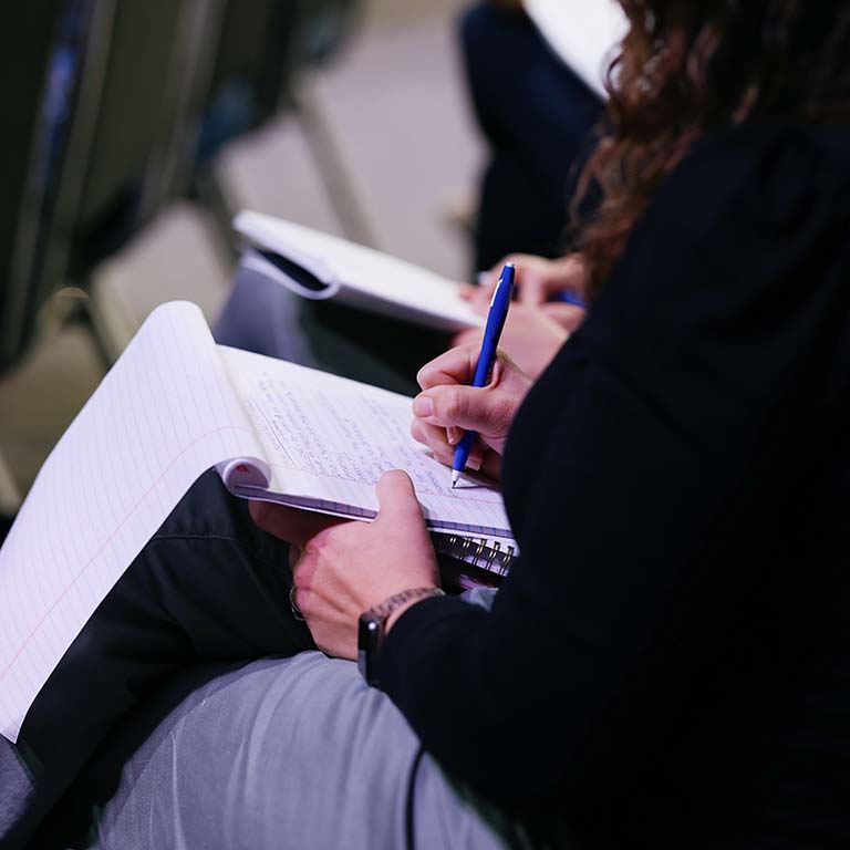 Student taking notes during class at KINEO