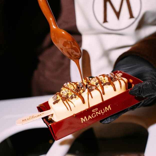 Magnum ice cream bar drizzled with caramel sauce and topped with gold leaf