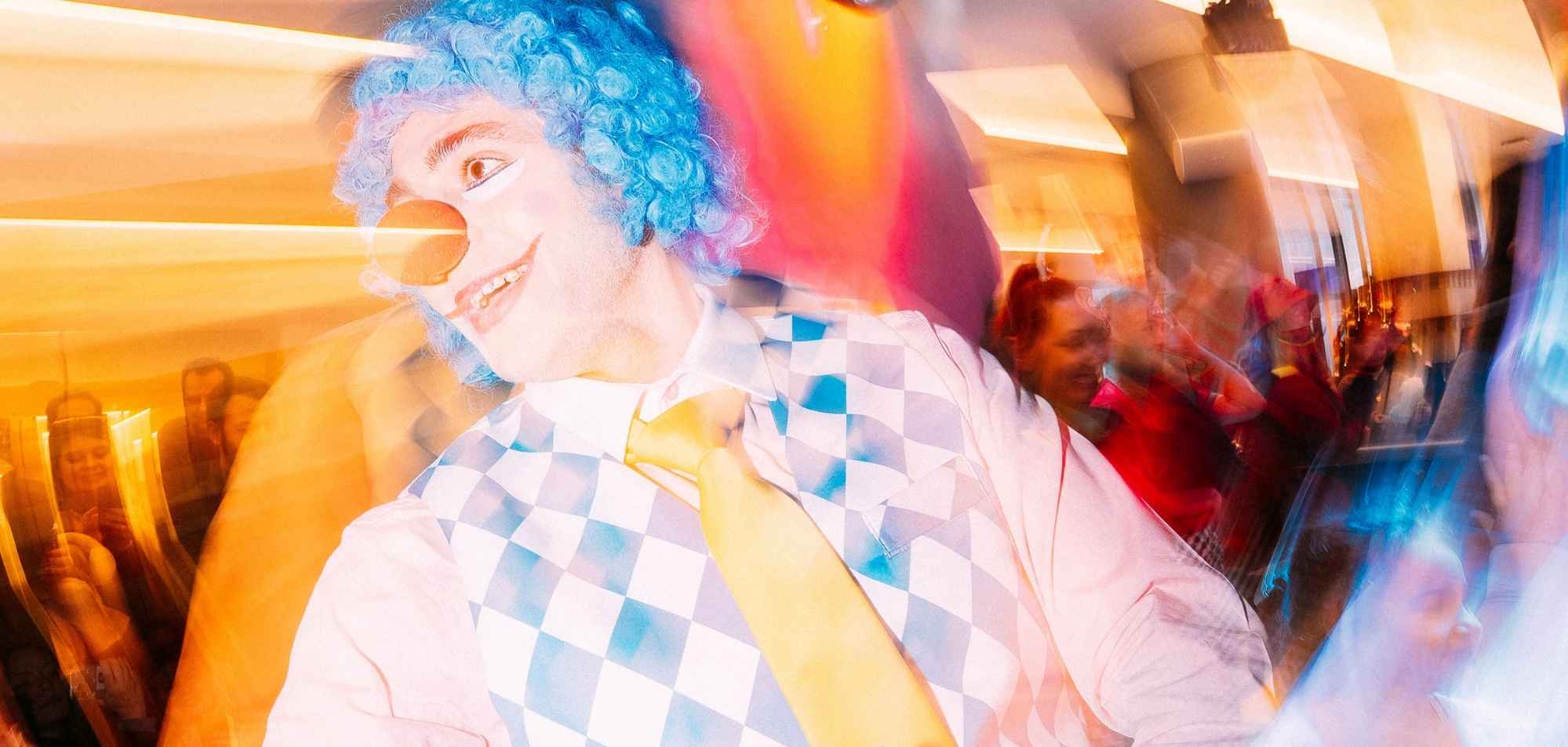 Colorful portrait of person with blue curly hair at vibrant party, wearing checkered outfit