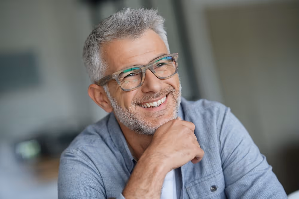 A man with glasses is smiling for the camera.