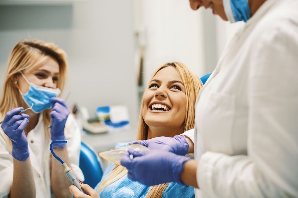 A woman getting her teeth checked by a dentist.