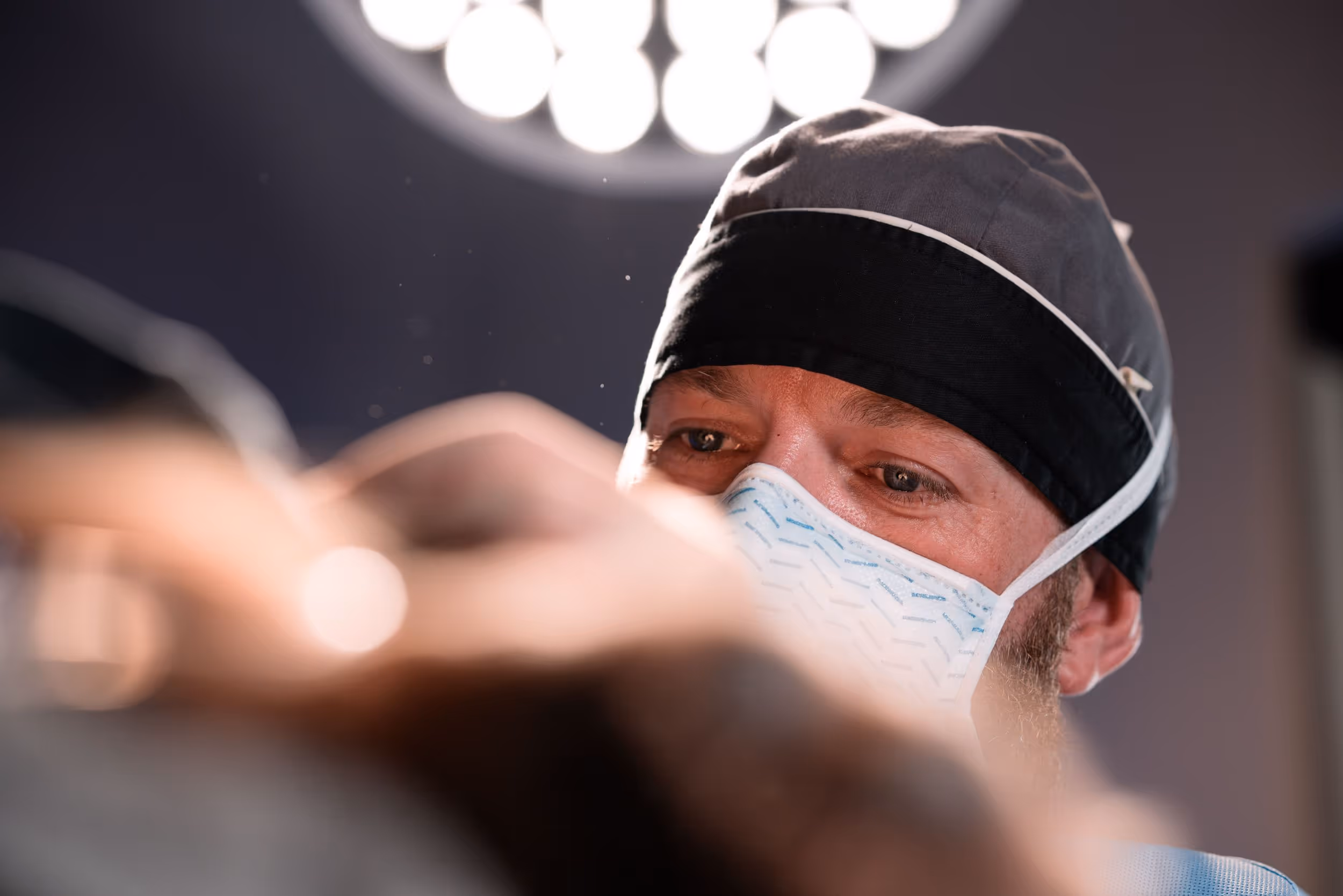 A man wearing a surgical mask in a room.