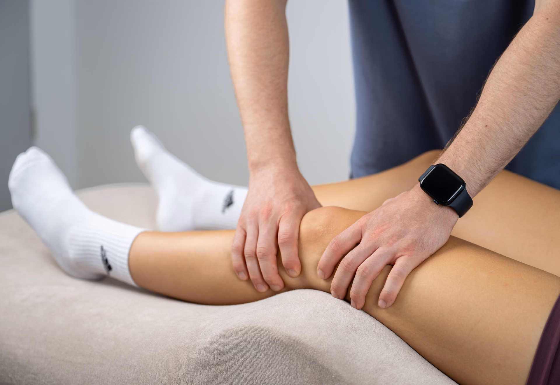 Person erhält eine Kniebehandlung von einem Physiotherapeuten.