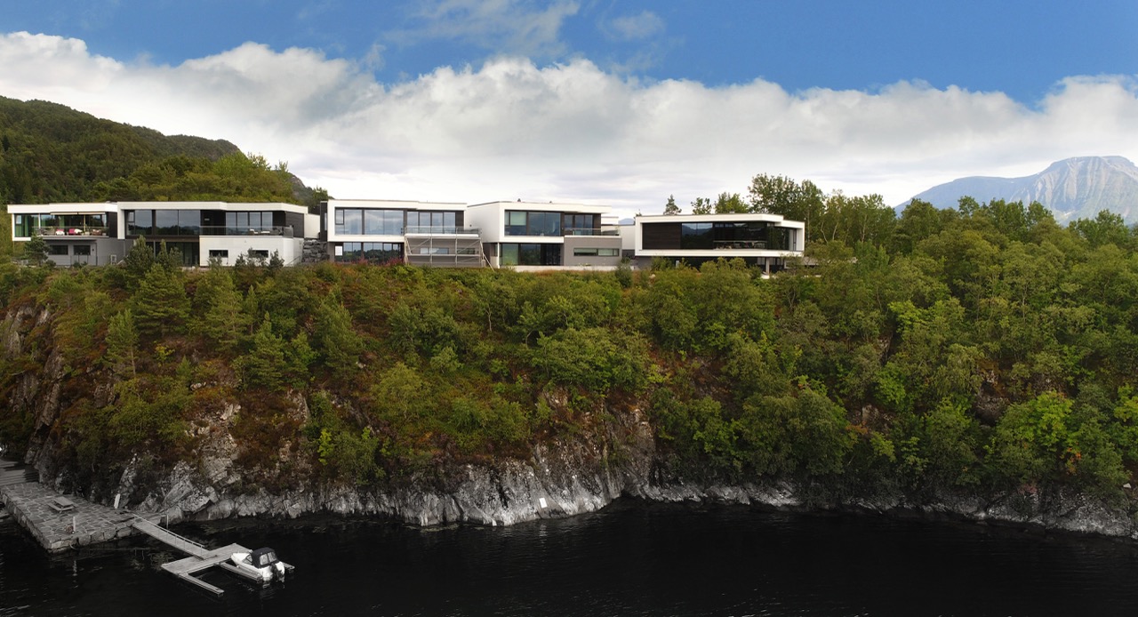 Sjøfasade av moderne boliger på Gullatoppen, plassert høyt på klippe med utsikt mot fjorden.