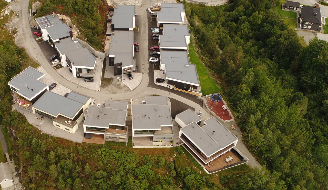 Dronefoto av boligene på Gullatoppen, med tydelig infrastruktur, lekeplass og grønne omgivelser.