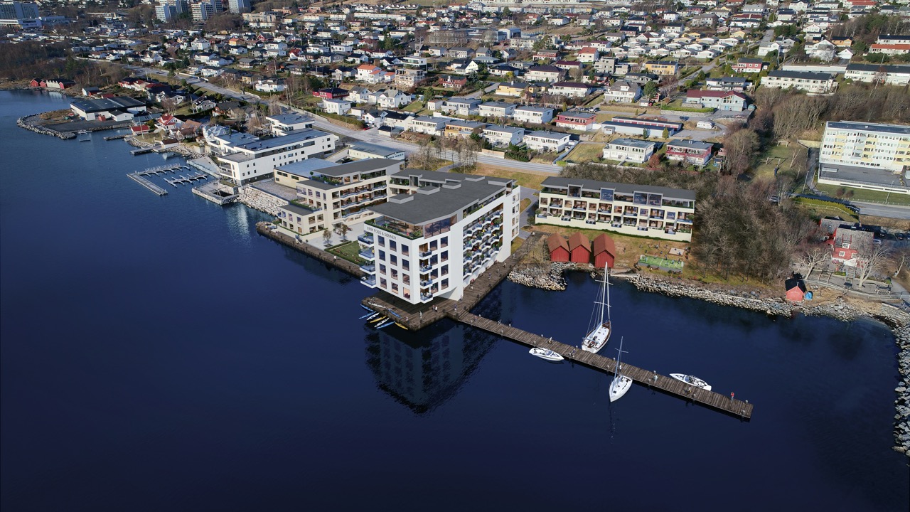 Droneperspektiv over hele prosjektområdet Foss med boligblokker, naust, marina og nærliggende bebyggelse.