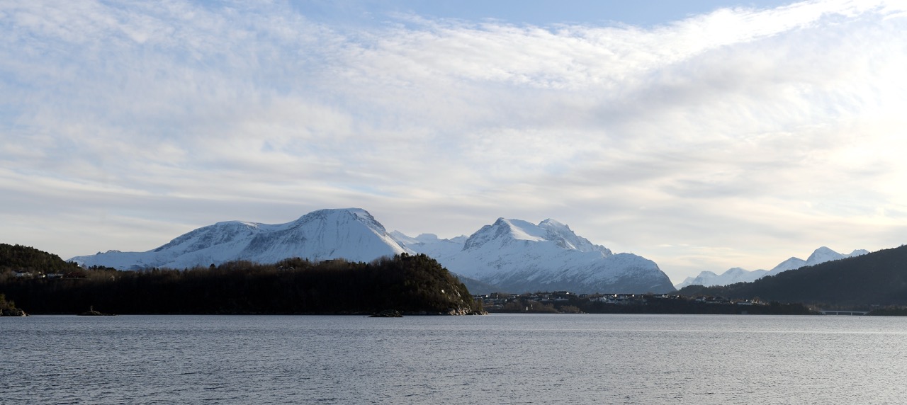Fjordutsikt fra Åse med snødekte fjell i bakgrunnen og øyer i forgrunn.