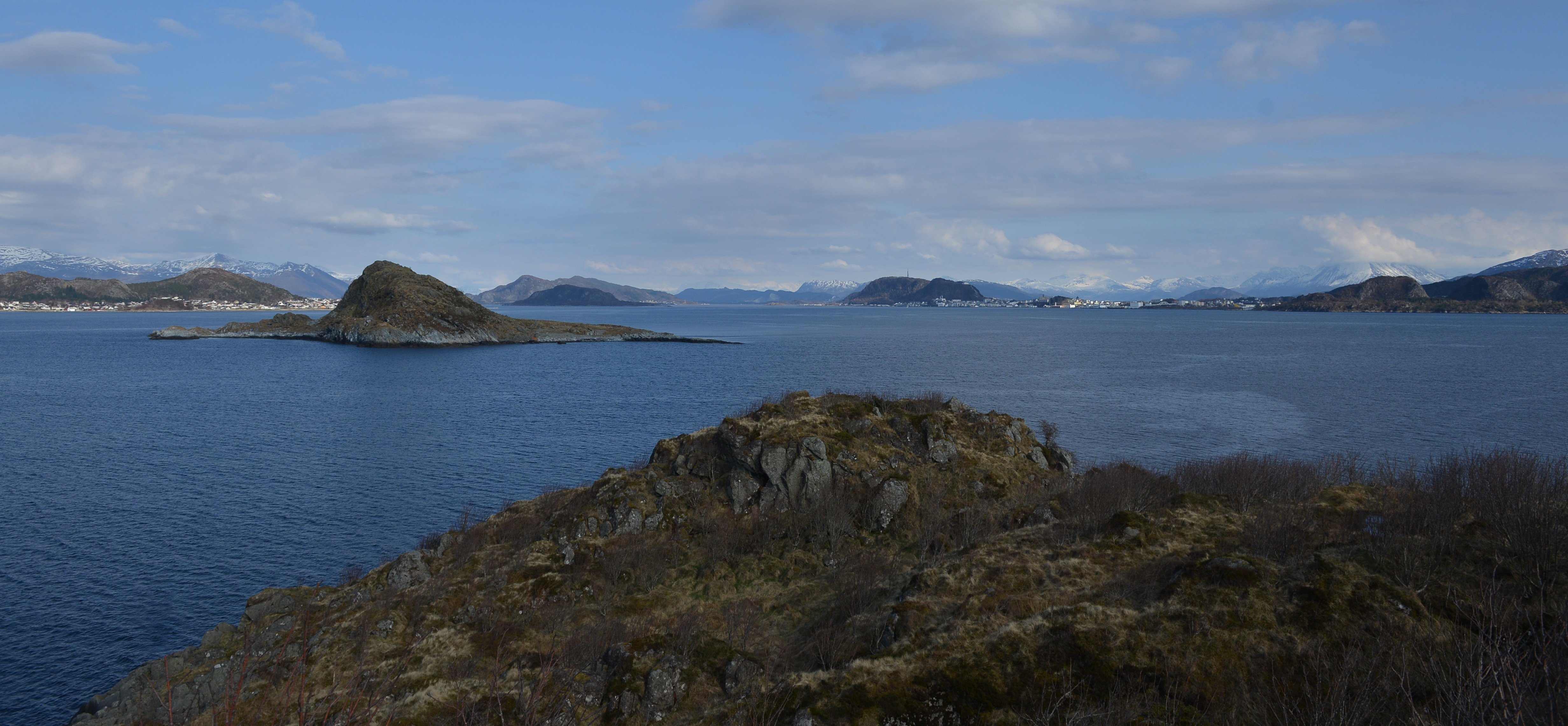 Utsikt fra Furkenholmen mot Ålesund og omkringliggende øyer og fjell i det fjerne.