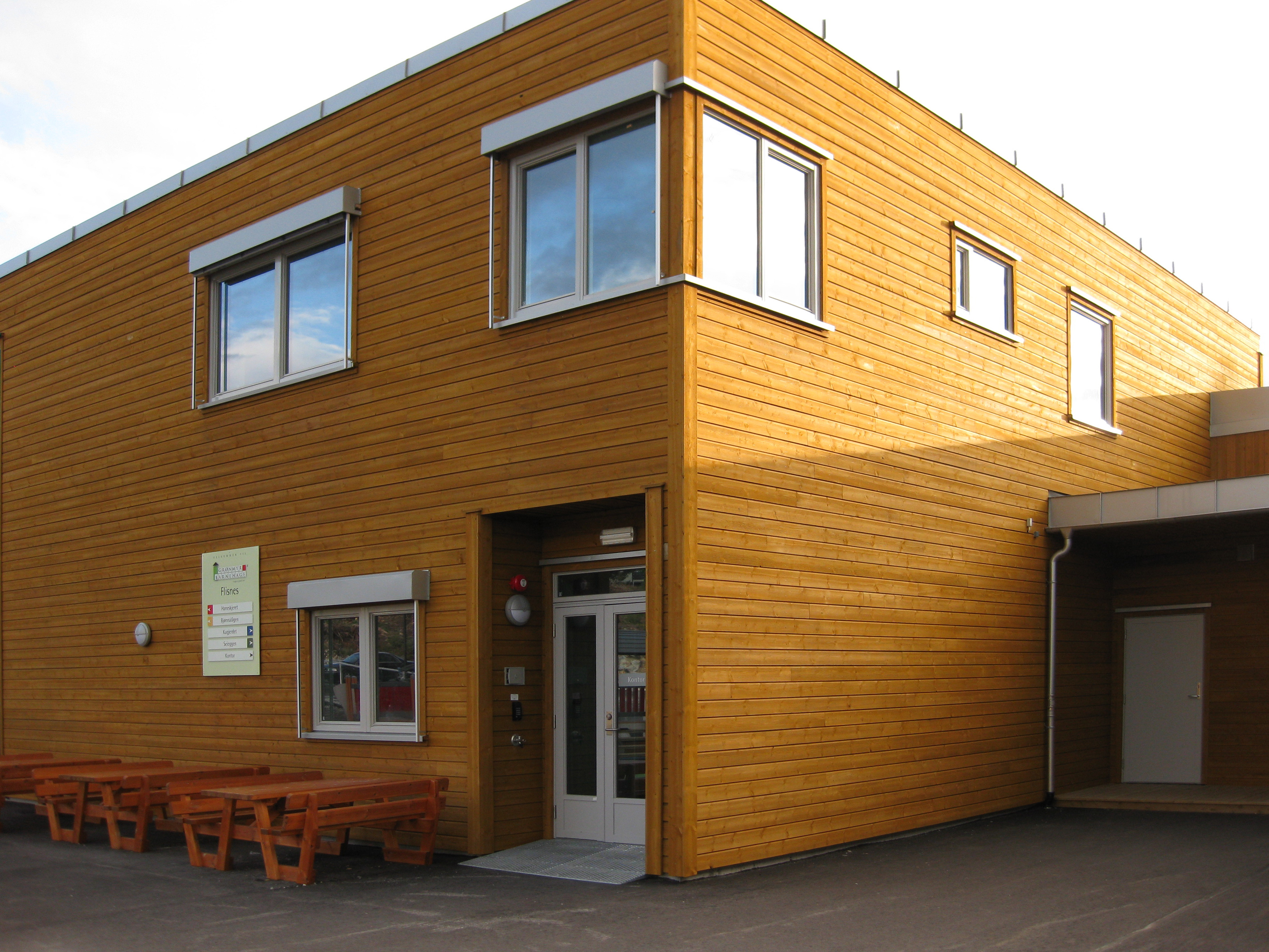Inngangsparti med benker og oversiktstavle utenfor Gnist-barnehagebygning.