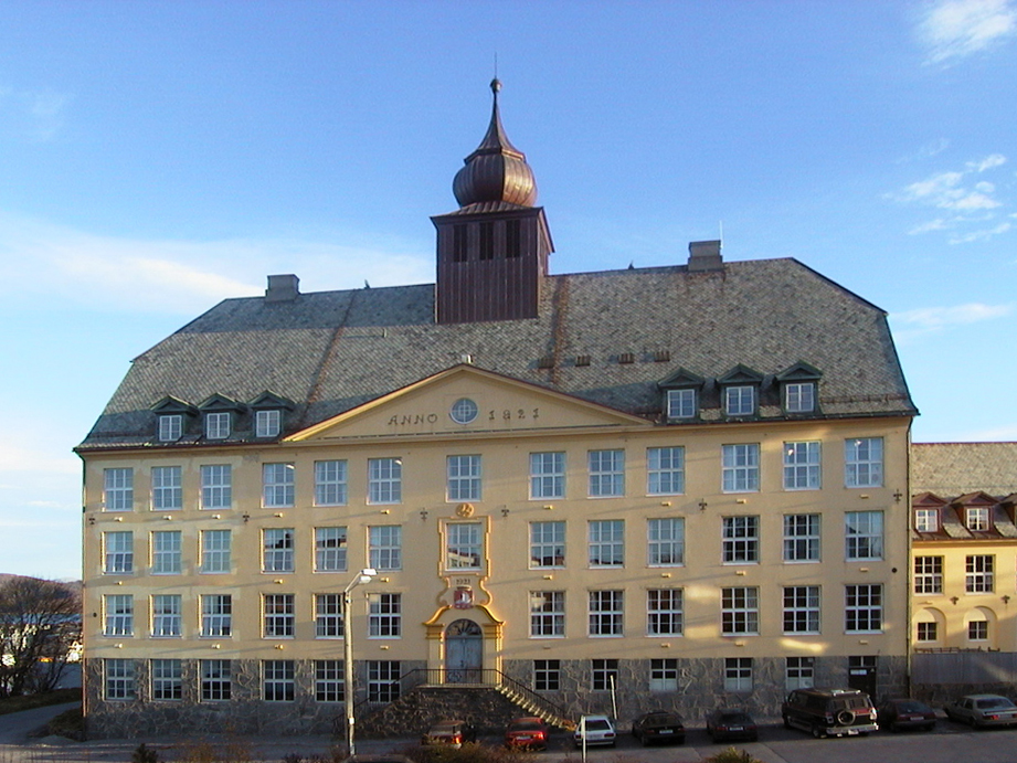 Fasadebilde av hovedinngangen til Aspøy skole med årstallet 1921 og tårnet i midten.
