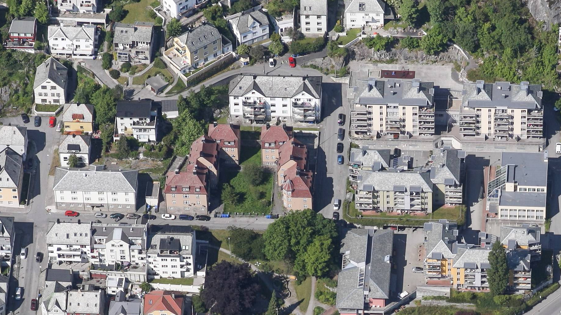 Dronefoto av kvartalet i Fjellgata 41/49, med fire symmetriske blokker omgitt av nyere bebyggelse.