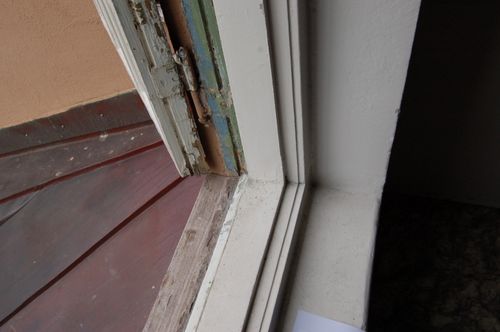 Detalj av originalt vindu med synlige eldre malingslag og beslag.