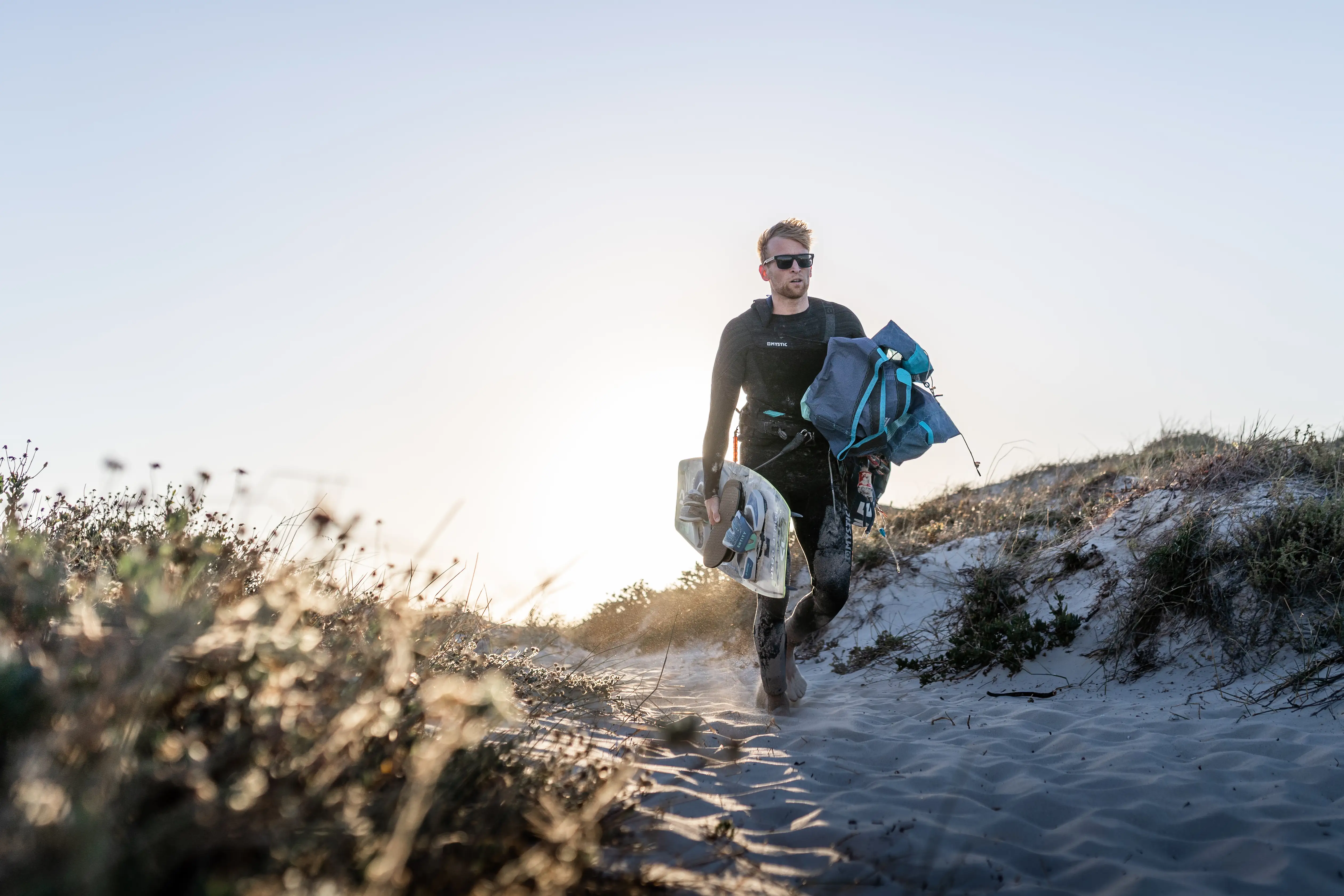 Rider carrying gear at a Cape Town beach launch — kitesurf photographer Cape Town