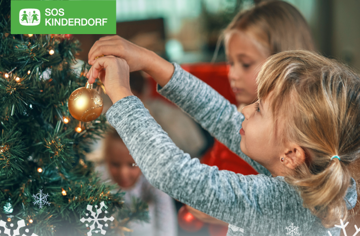 Kinder vor einem Weihnachtsbaum
