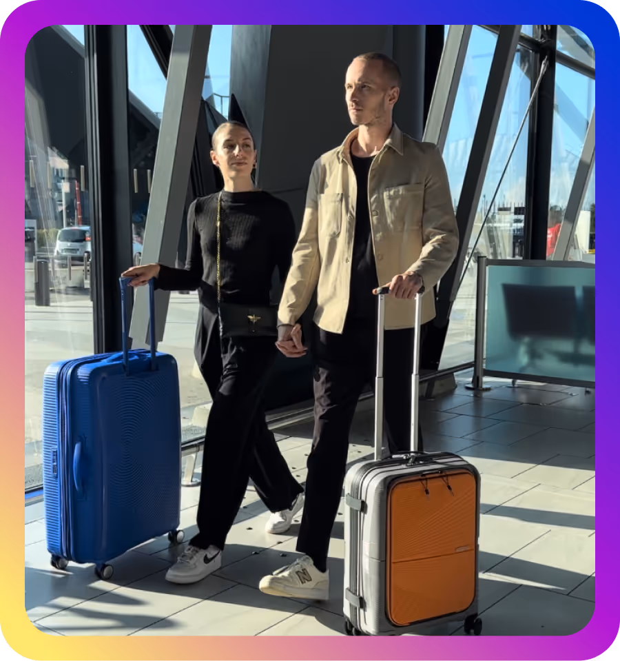ilona et son copain qui se tiennent la main avec des valises à l'aéroport