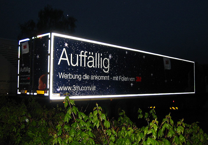 Ein beleuchteter LKW mit dem Schriftzug "Auffällig"