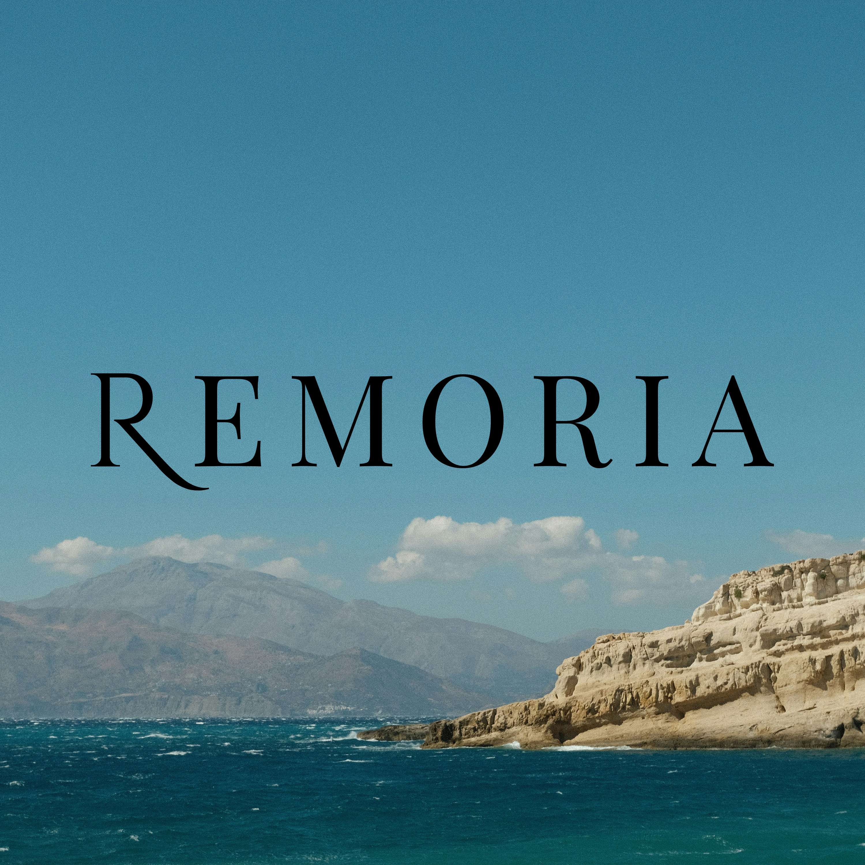 REMORIA wordmark over a Mediterranean coastal landscape with turquoise sea, limestone cliffs, and distant mountains under a clear blue sky. The visual evokes timelessness, natural elegance, and poetic serenity.