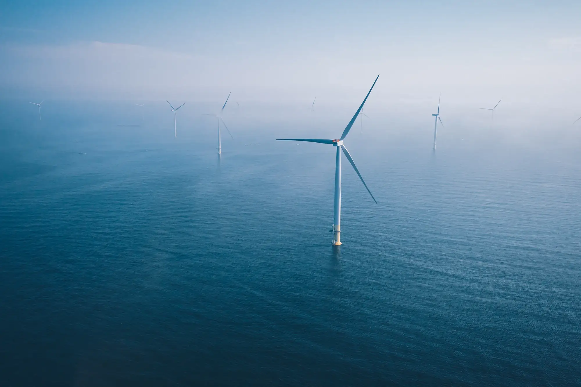 Offshore wind windmills in beautiful blue ocean