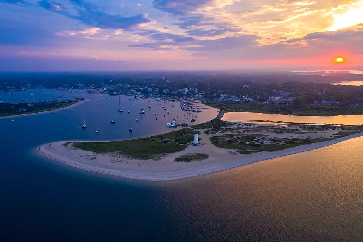 A landscape showing boats in the harbor and a beautiful sunset