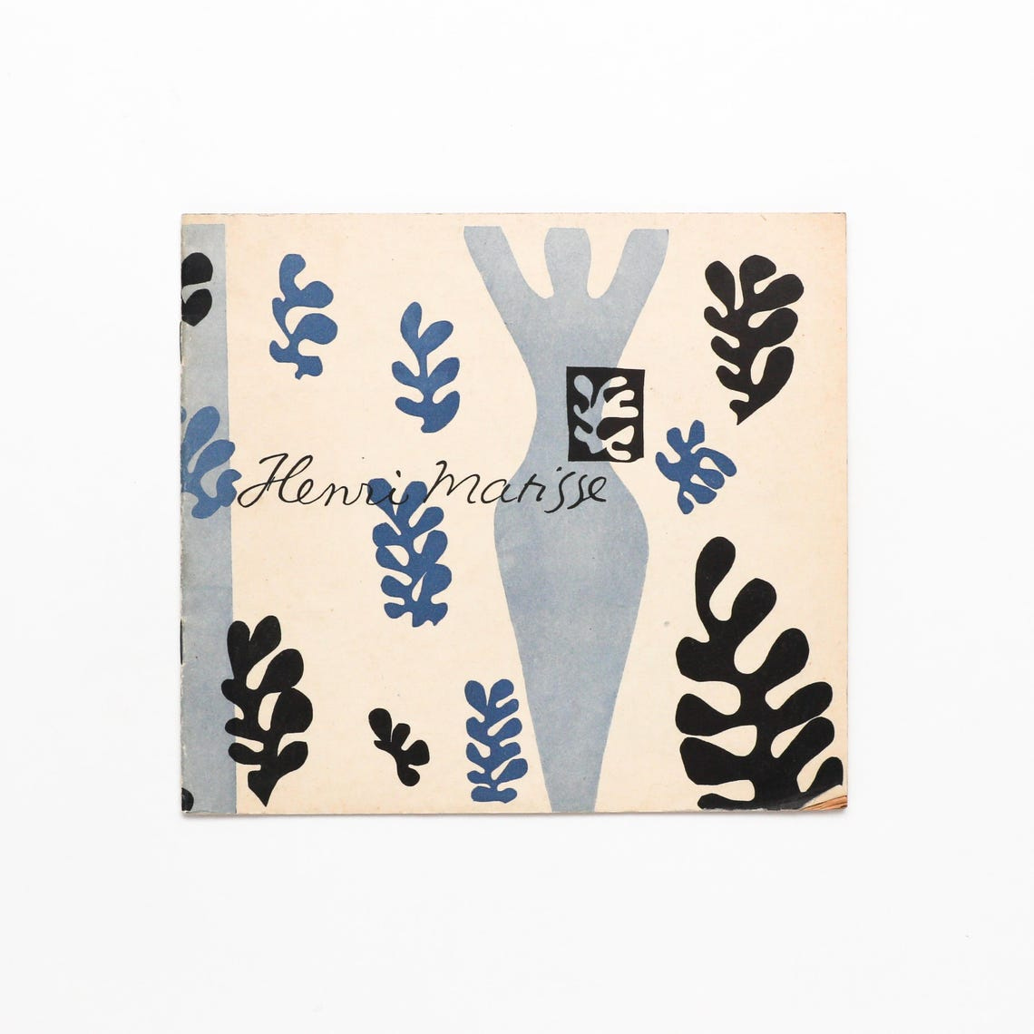 May include: A blue and black illustration of a woman with raised arms, surrounded by blue and black leaf shapes. The text 'Henri Matisse' is written in cursive at the bottom of the image.