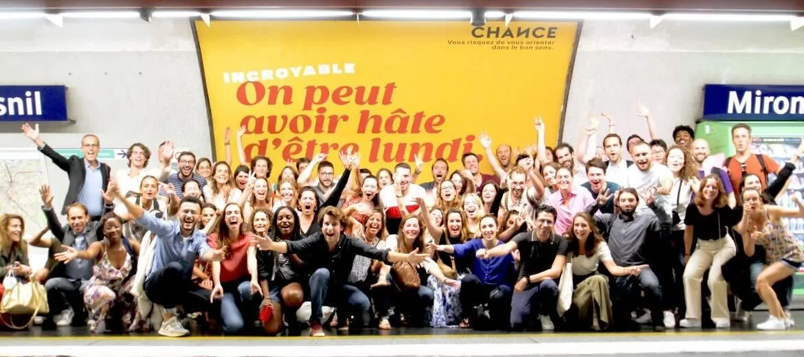 Membres du Collectif Chance devant l’affiche « On peut avoir hâte d’être lundi »