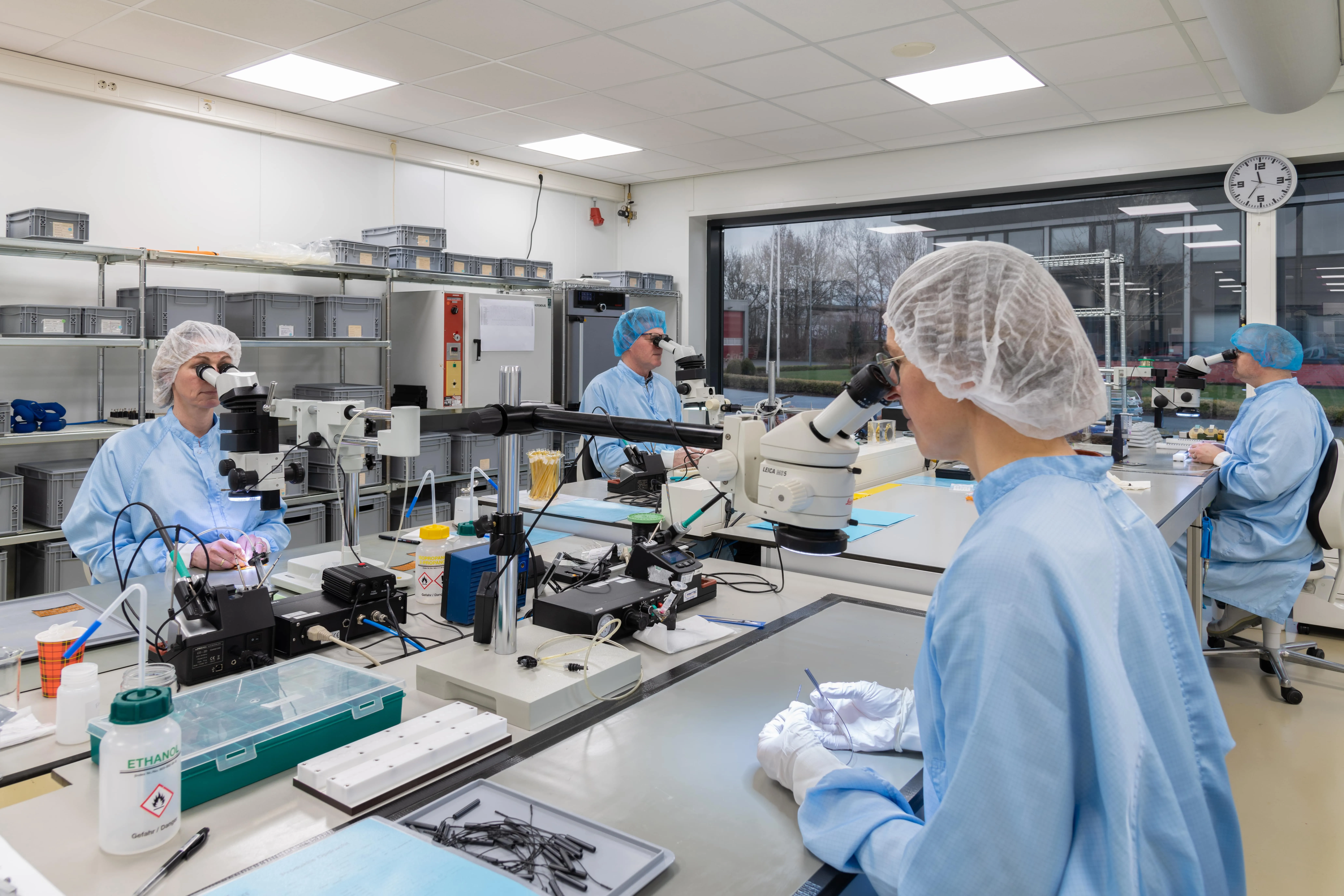 Millar employees use microscopes to make ultra-precise adjustments to devices in Millar’s microfoundry.