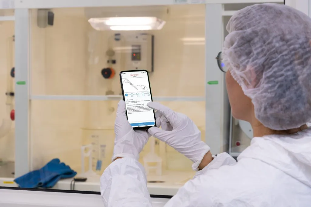A Millar employee uses a mobile device to get data from a temperature sensor.