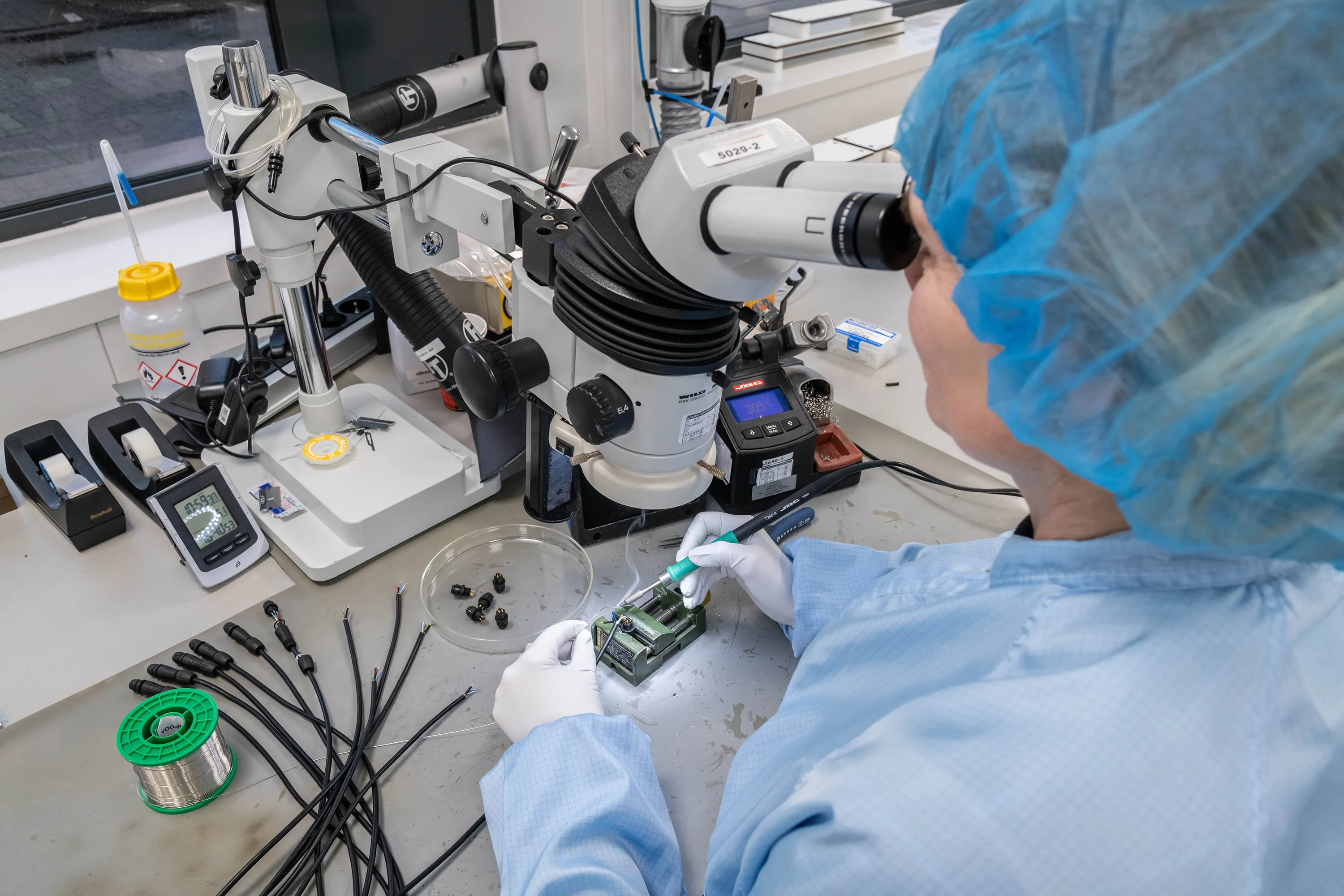 A Millar employee uses a microscope to work on a Millar ISFET pH Sensor. 