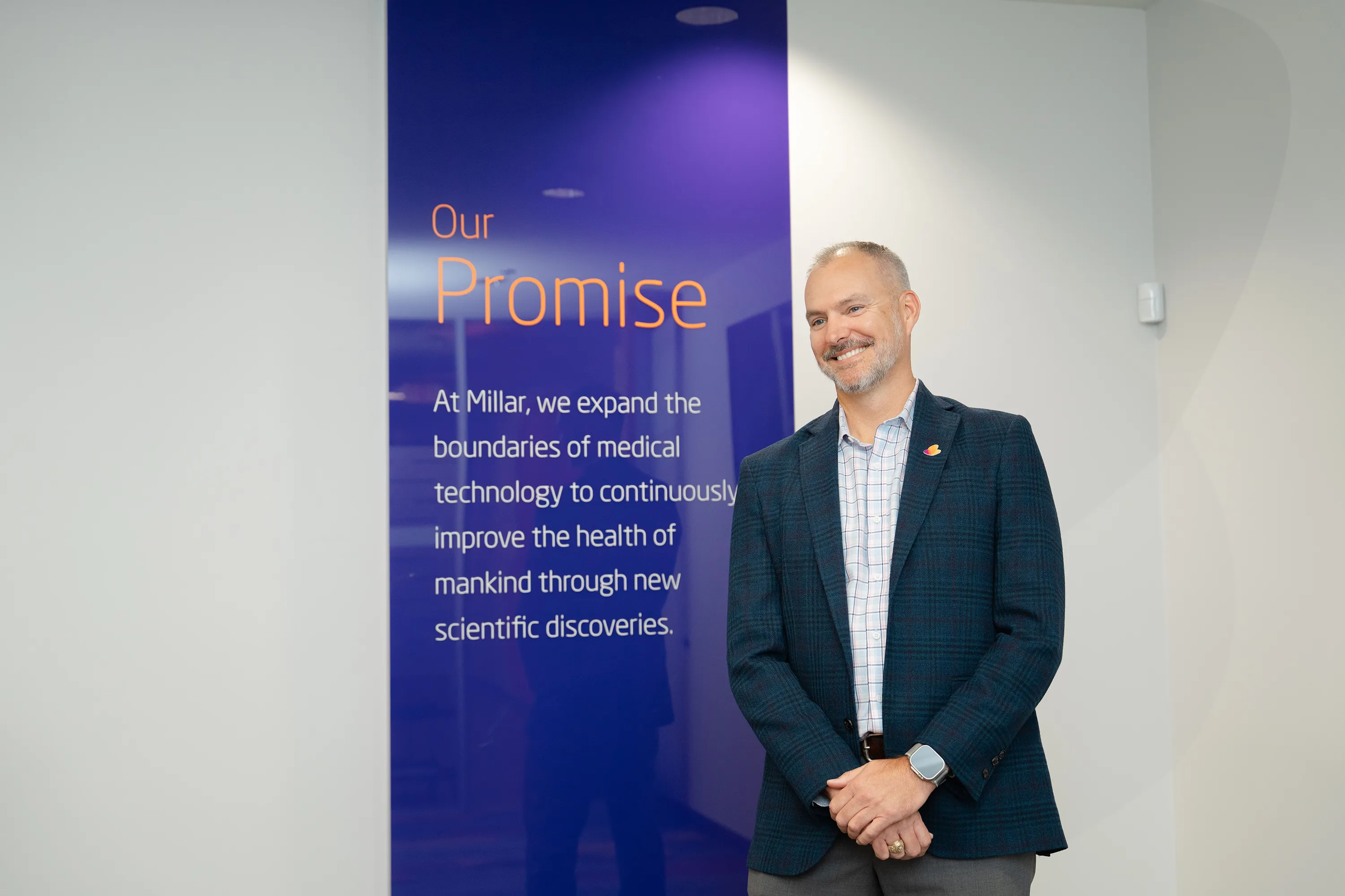 Millar president and CEO Tim Daugherty poses in front of a plaque showing Millar’s promise statement at Millar headquarters in Pearland, Texas.