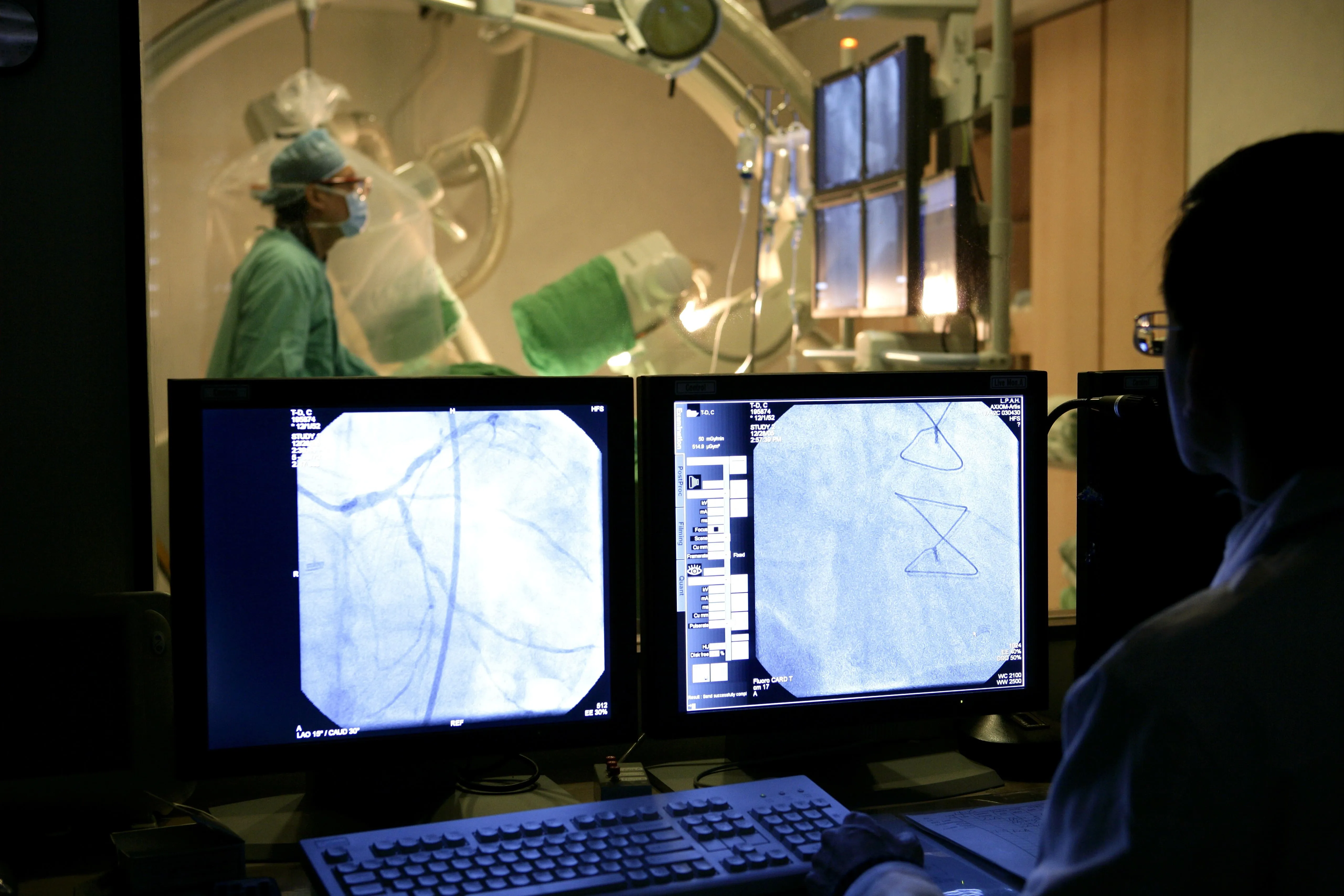 A medical doctor looks at images of a sensor implantation during a cardiovascular procedure.
