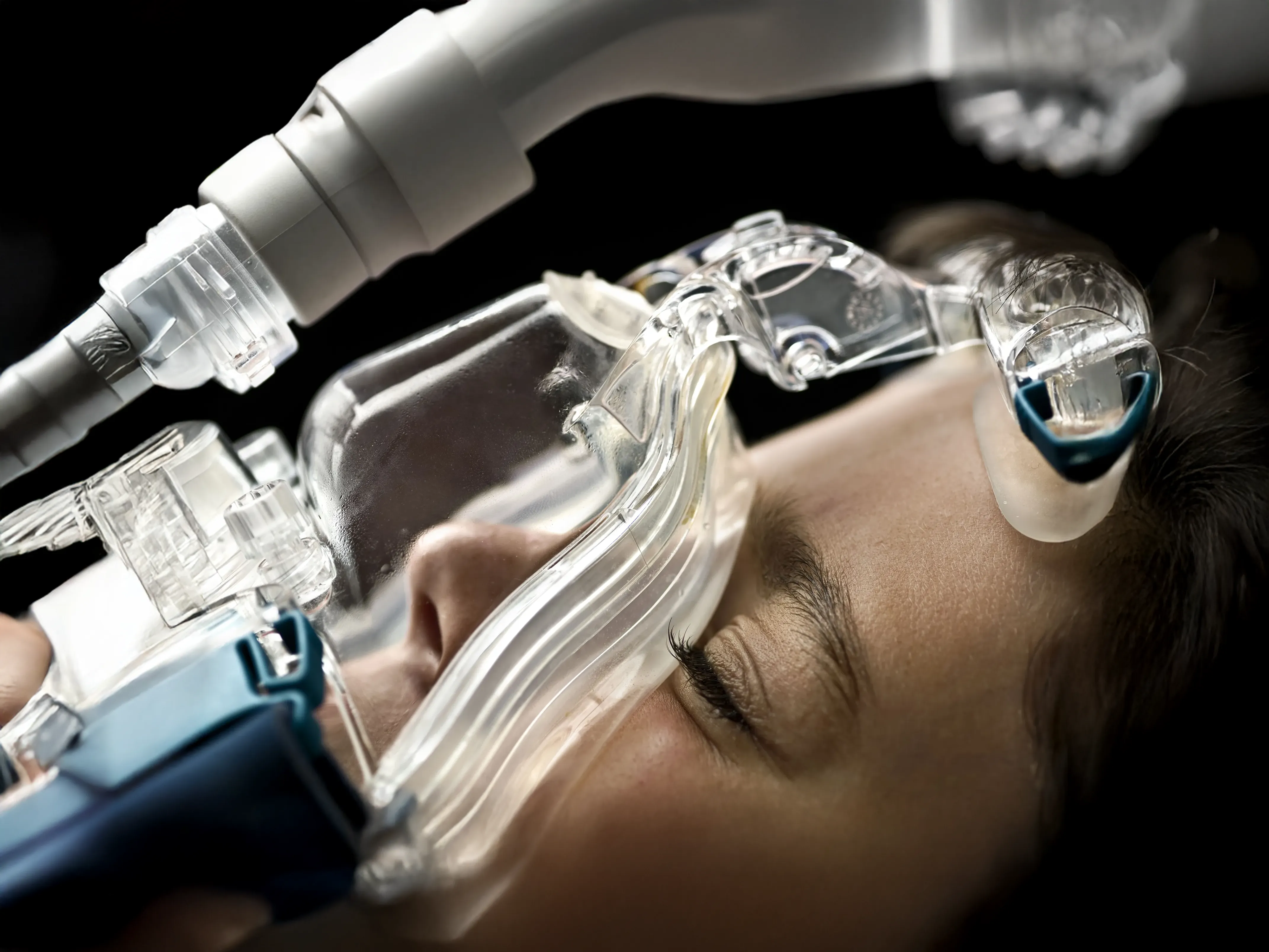 Close-up of a patient wearing a clear respiratory mask, representing the clinical application of advanced medical technology,