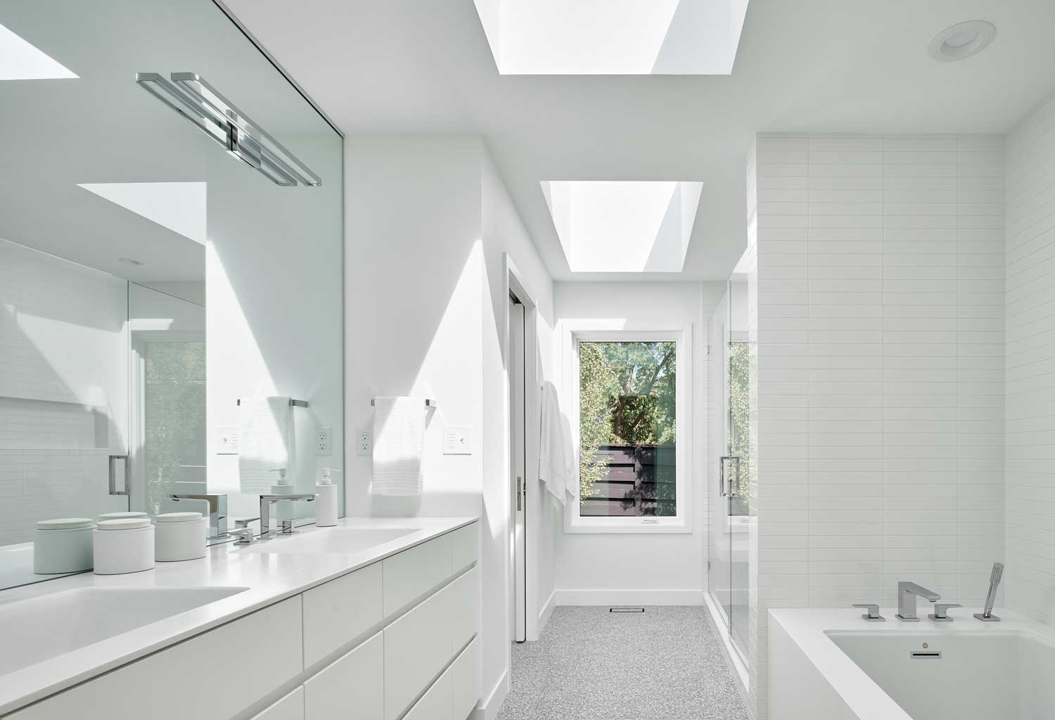 All white bathroom with large vanity and bathtub