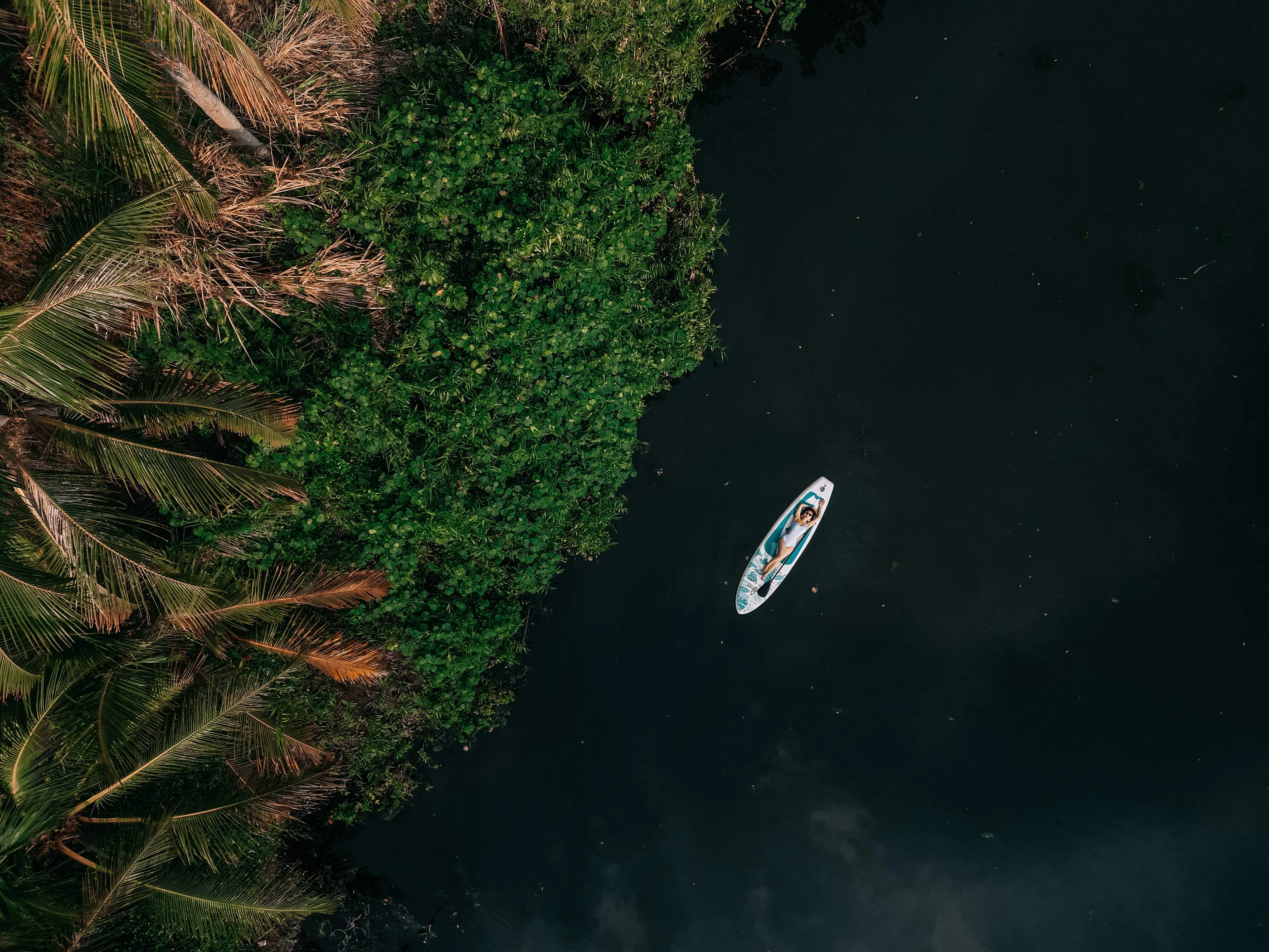 Grace is floating on a paddle board from an aerial view