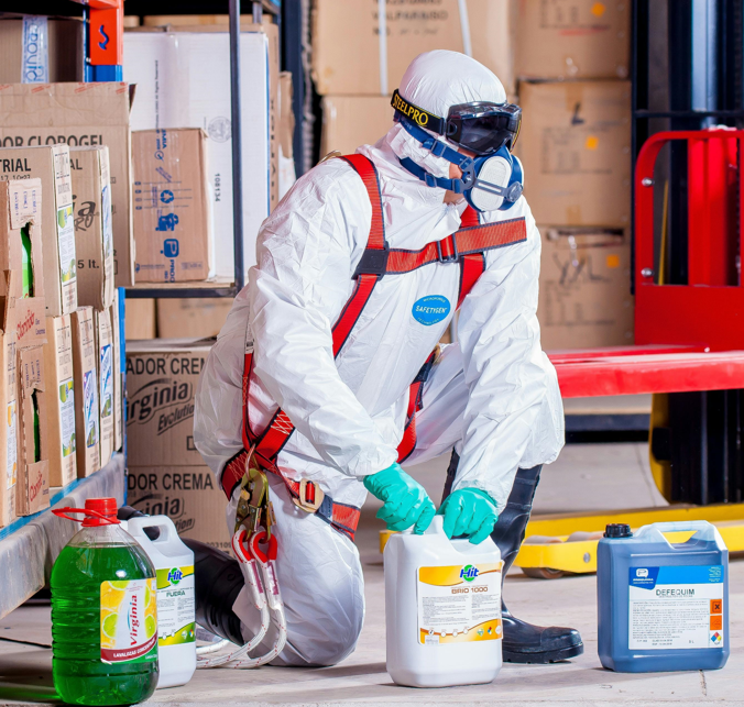 Man in hazmat suit with chemicals