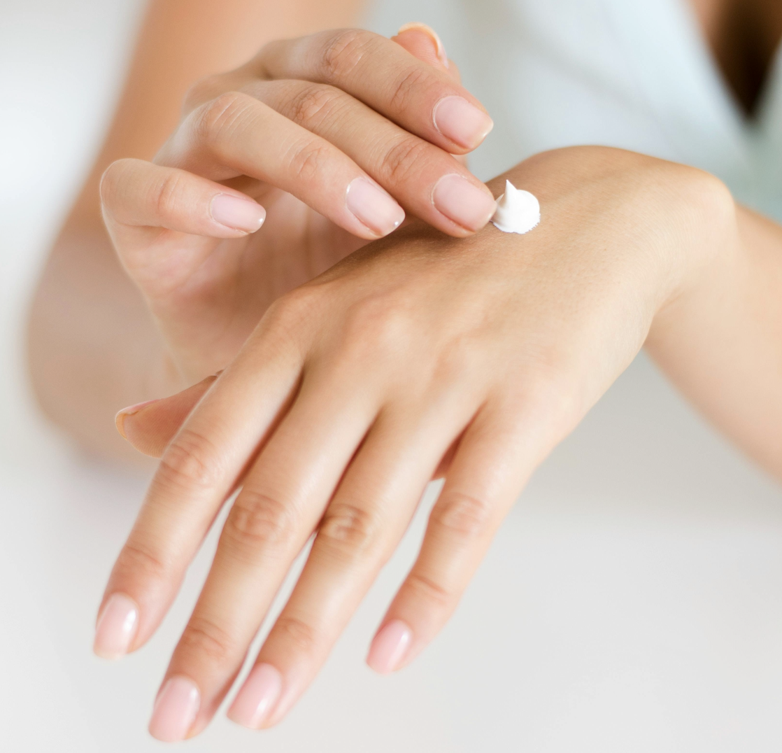 women applying cream on hands
