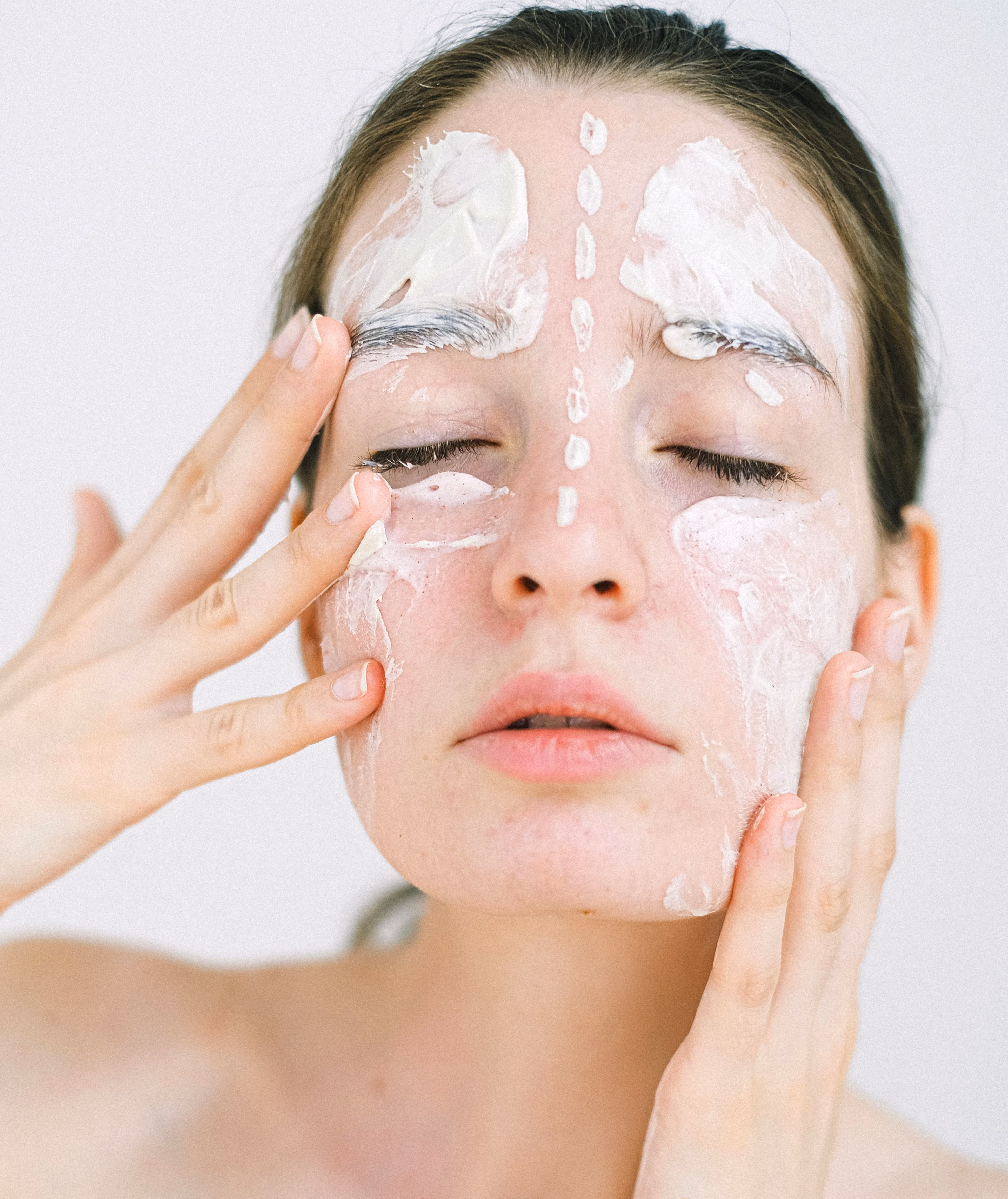 woman smearing cream on her face