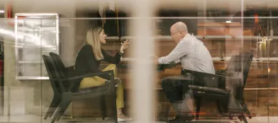 Two people discussing insurance in waiting area