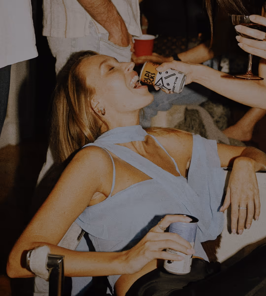 A lady drinks from a Goldi Locks can that is served to her.