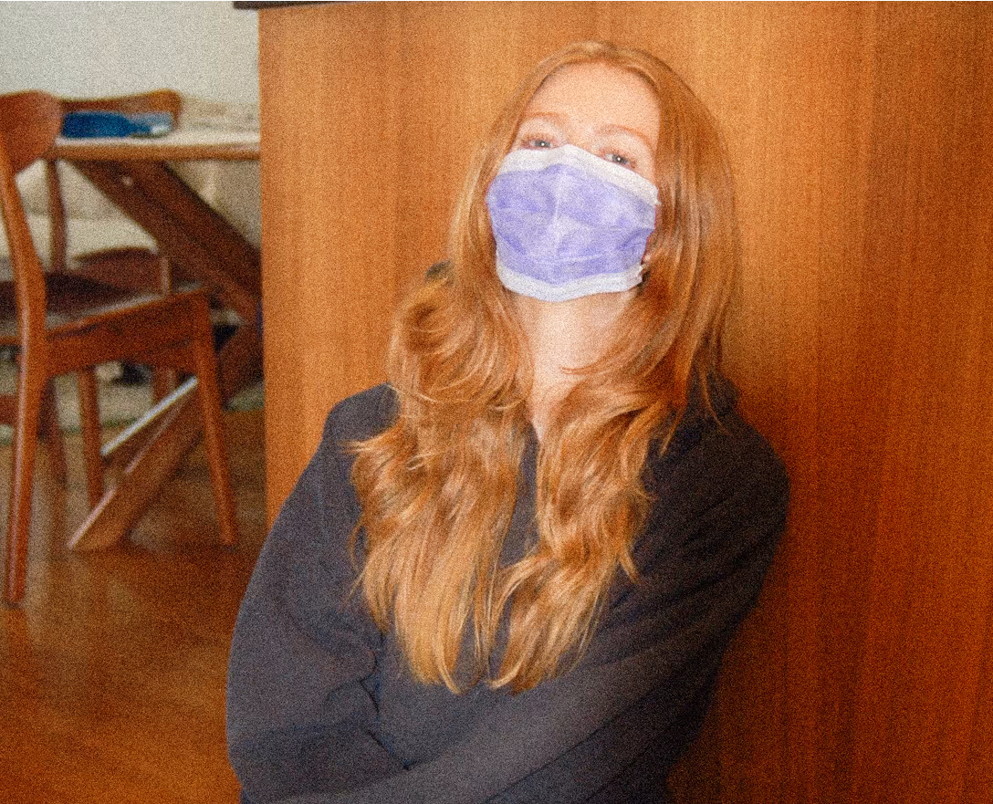 A lady wearing a mask stares at the camera.