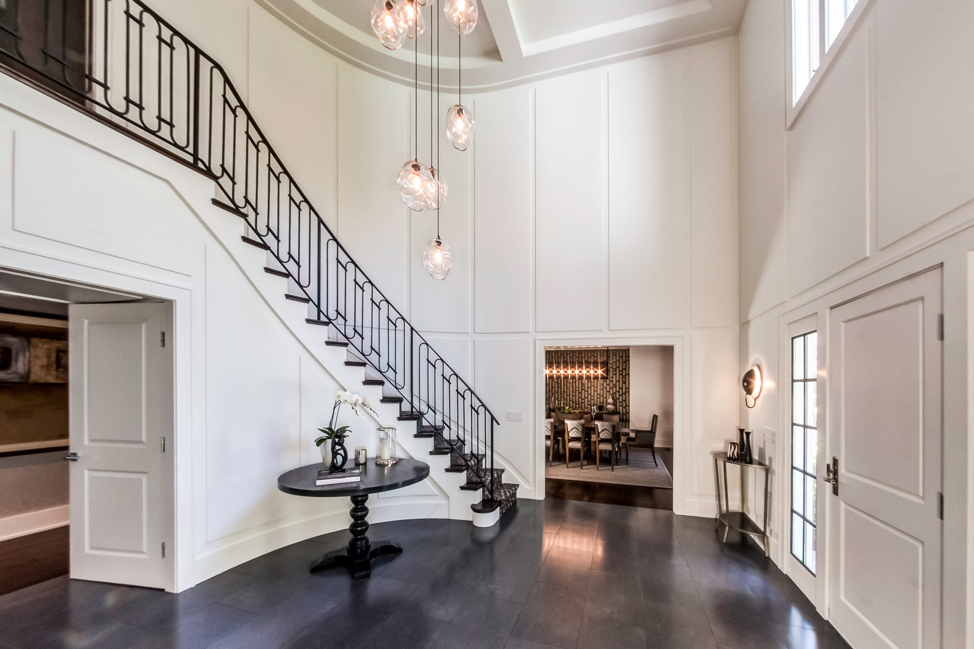 Grand foyer with dual staircases and chandelier.