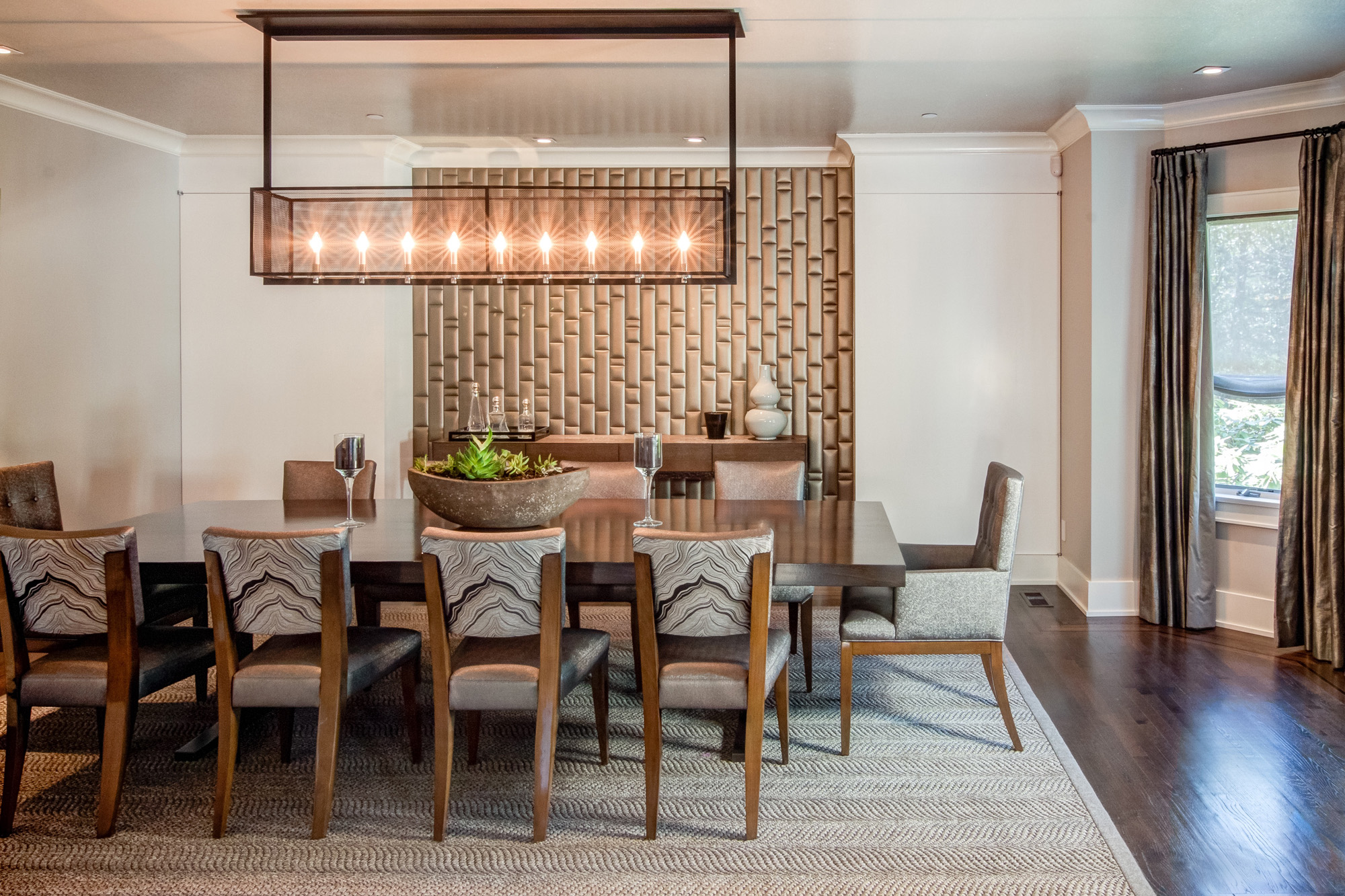 Dining room with modern chandelier and long table.