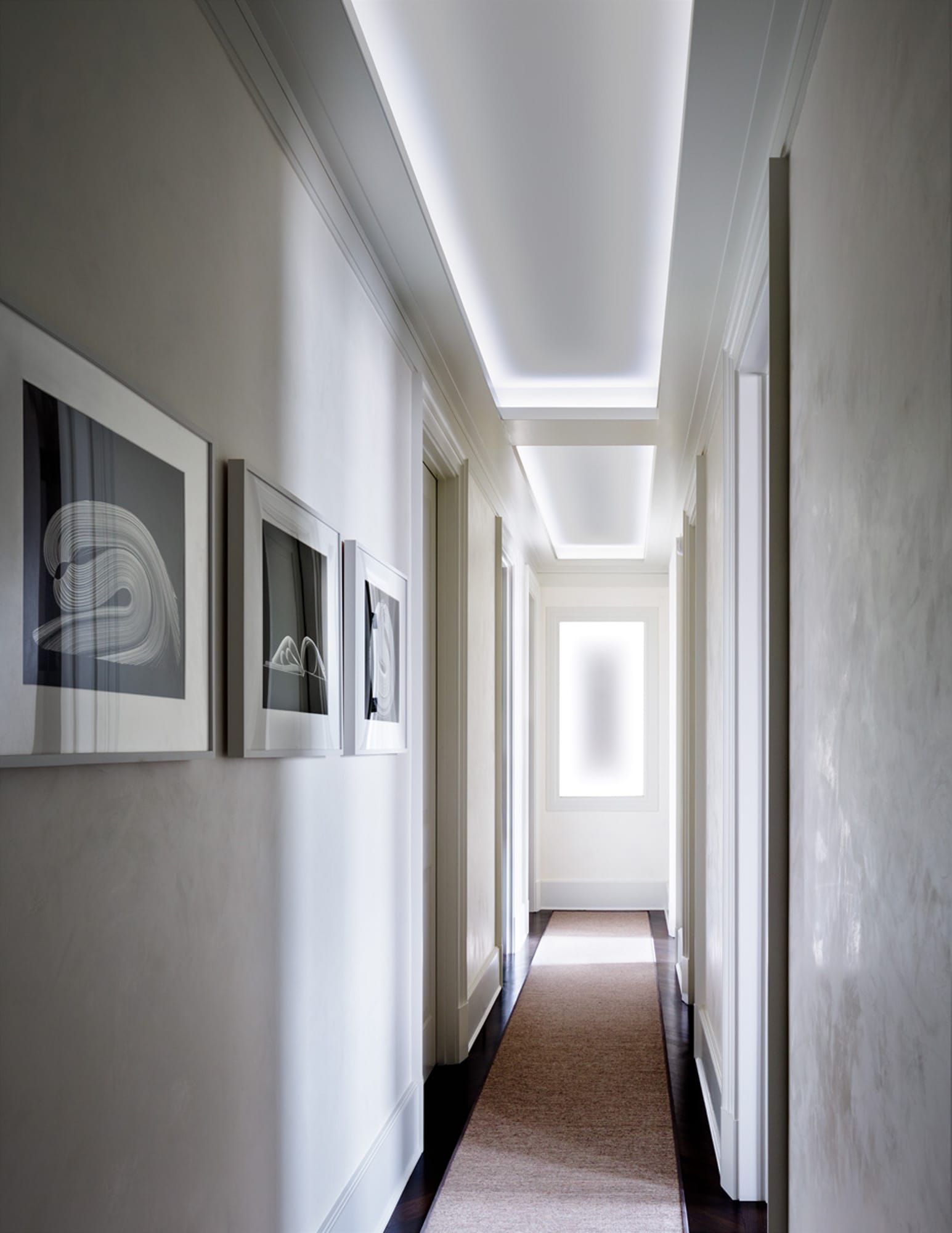 Modern hallway with artwork and recessed lighting.