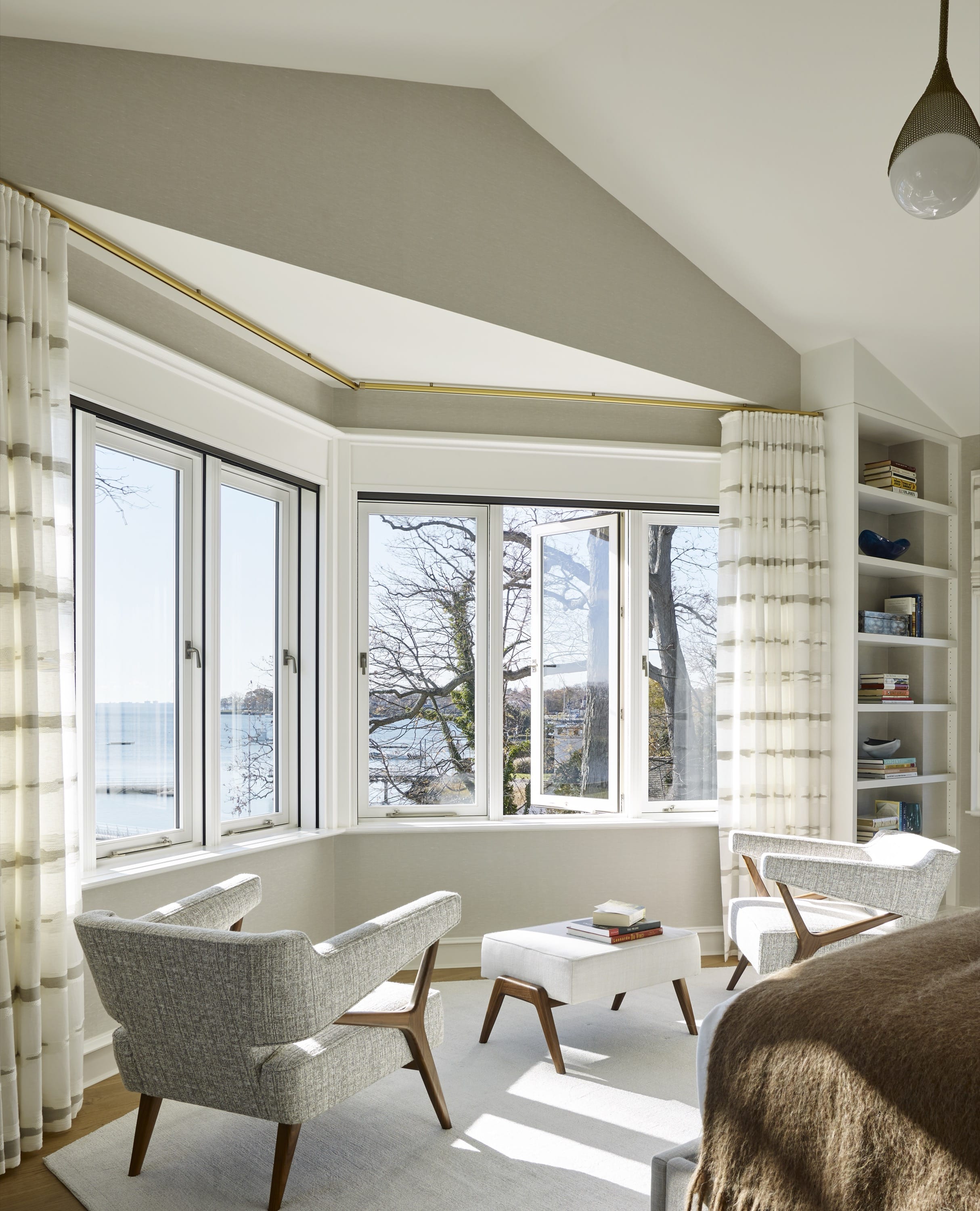 Sunroom with wicker chairs and large windows.