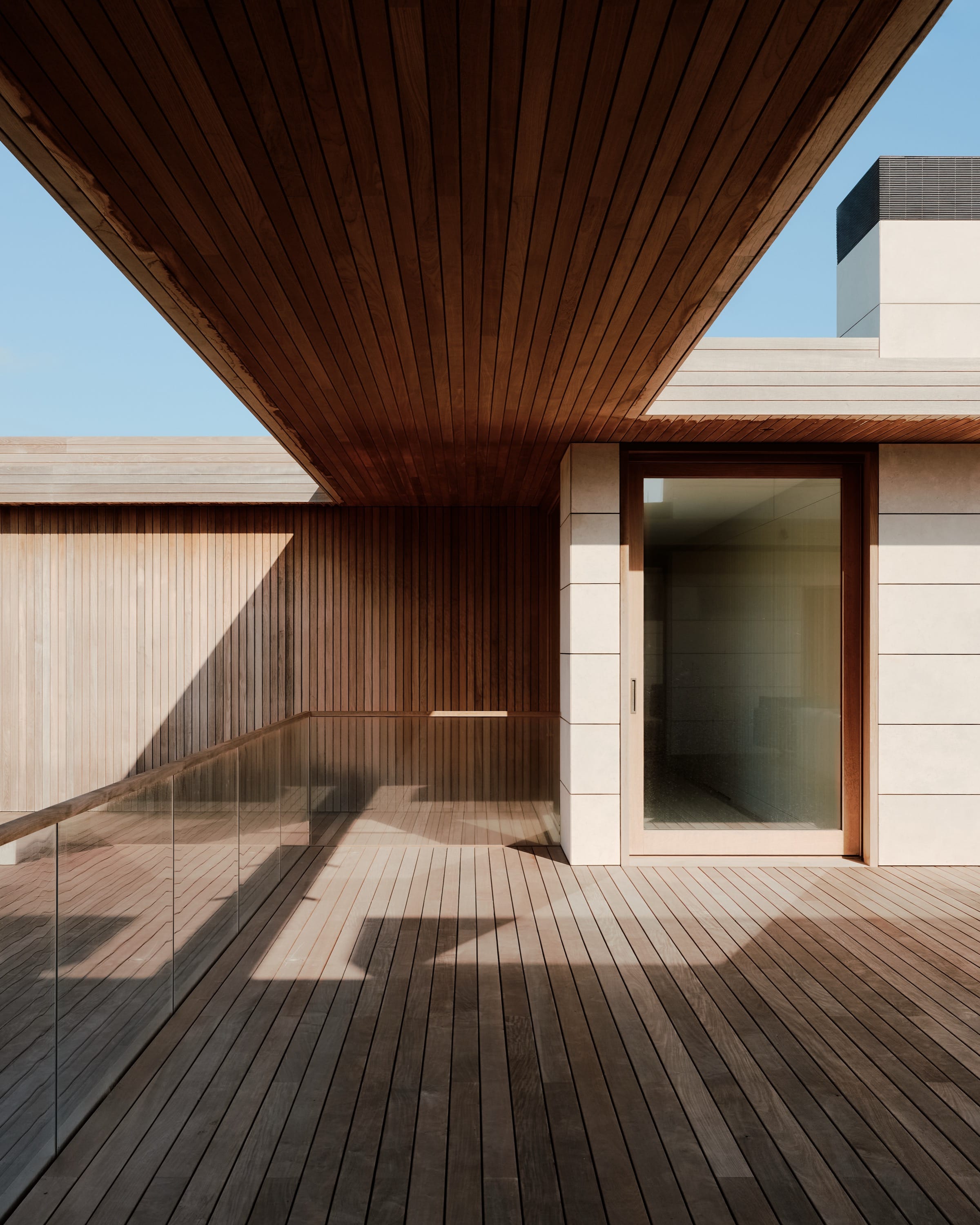 Modern courtyard with wood deck and shadows.