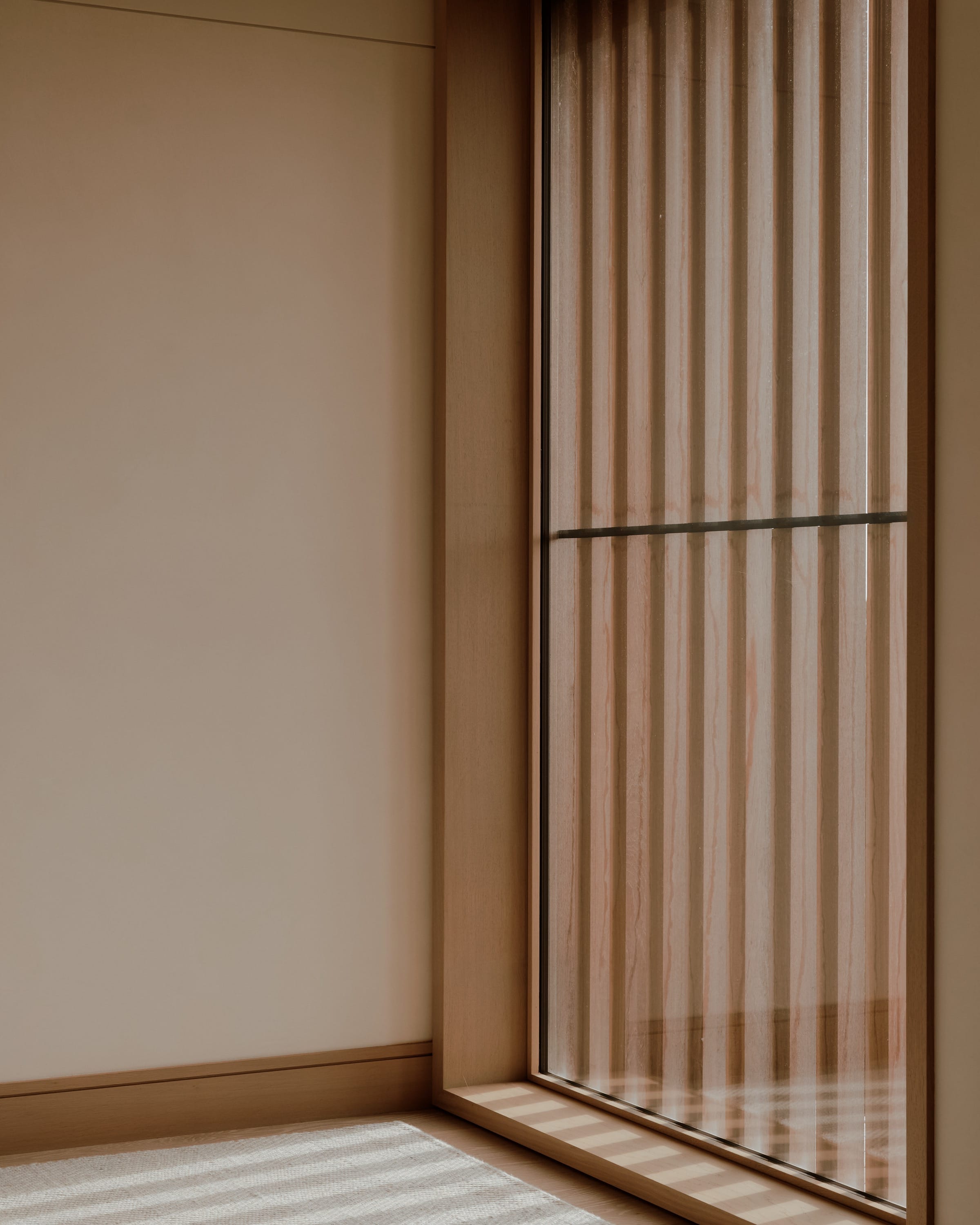 Bedroom corner with wood slats and minimal decor.