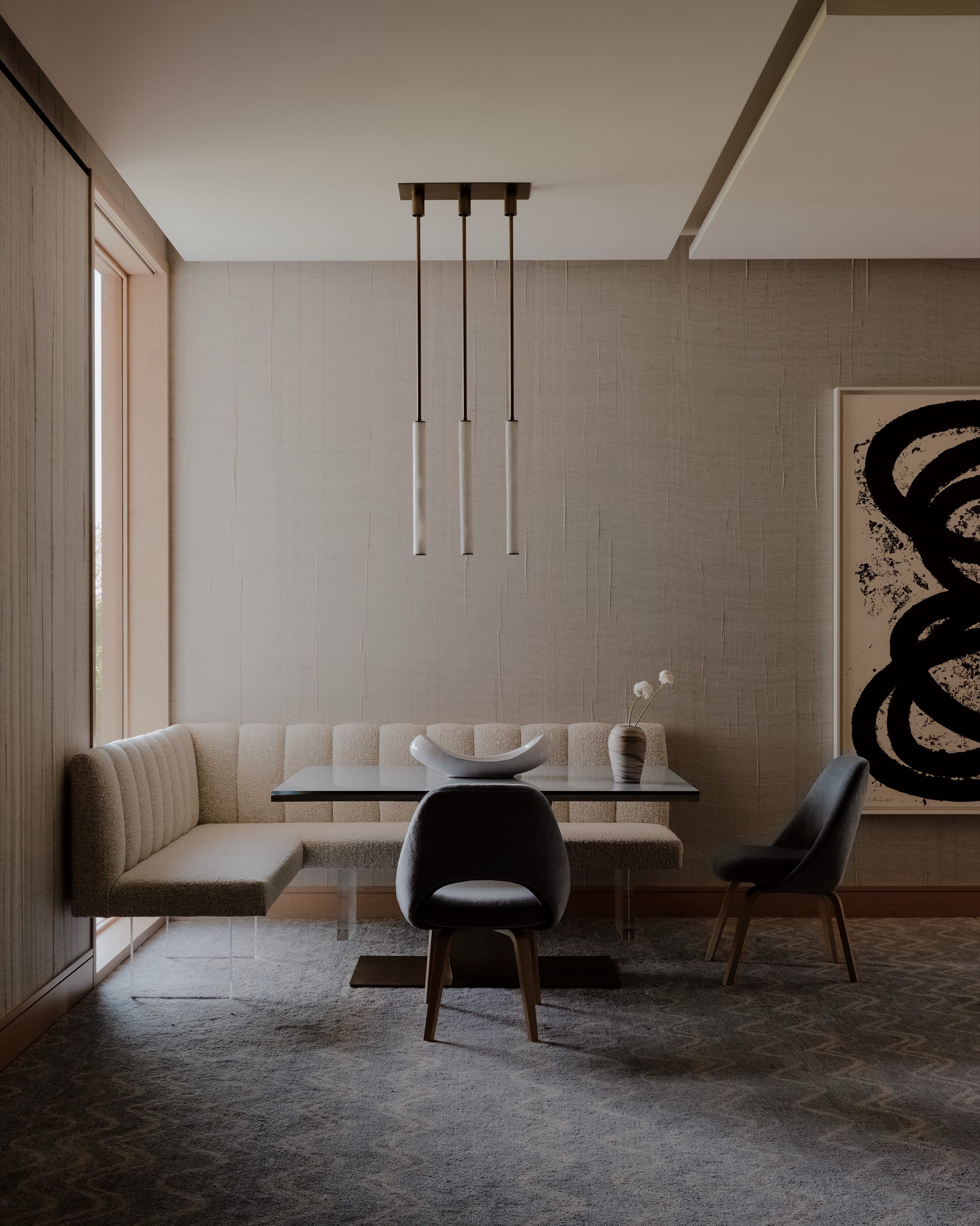Sitting area with armchairs, modern art, and neutral tones.