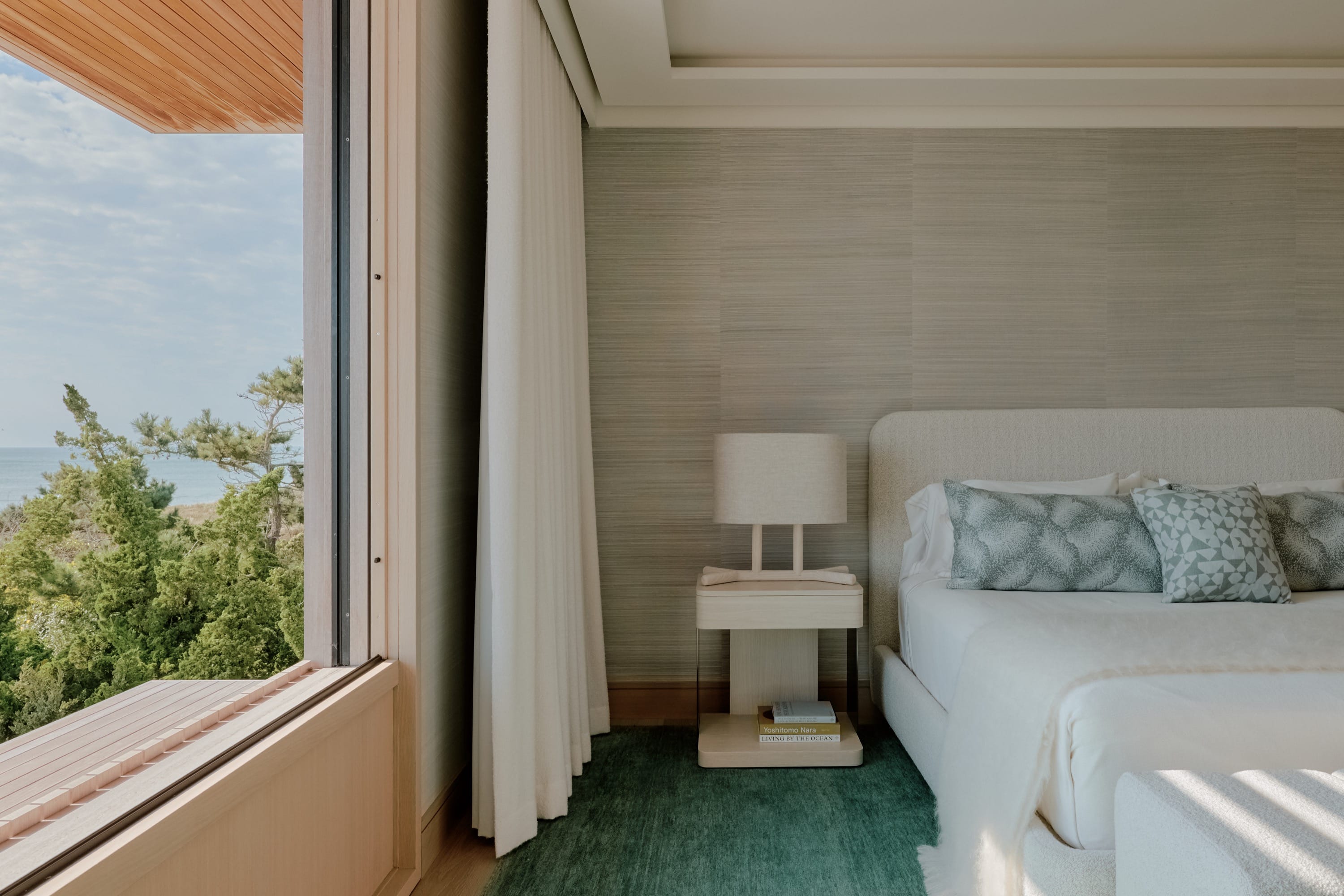Bedroom with light wood furnishings and green carpet.