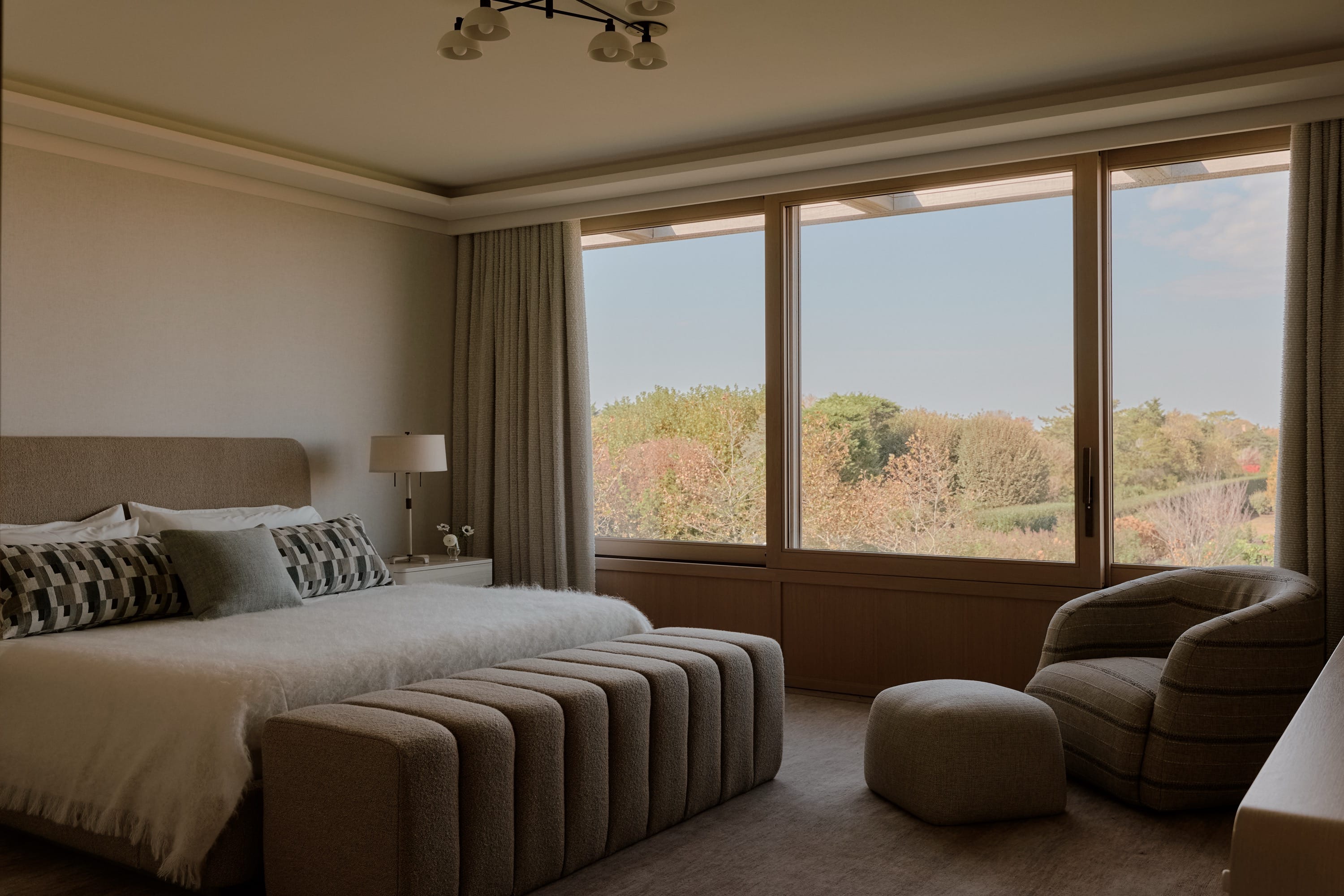 Bedroom with large bed, seating area, and ocean view.