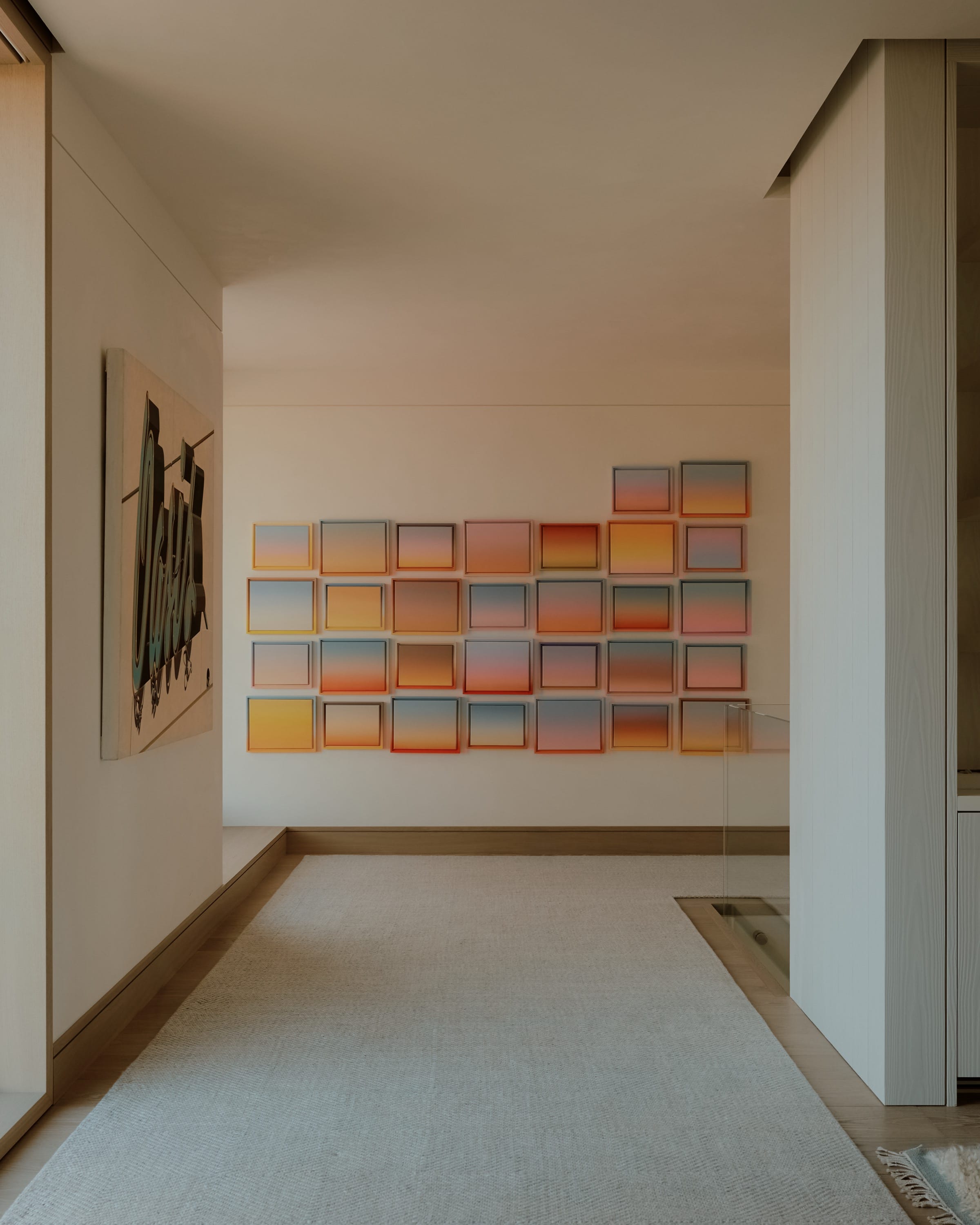 Hallway with abstract artwork and wood flooring.